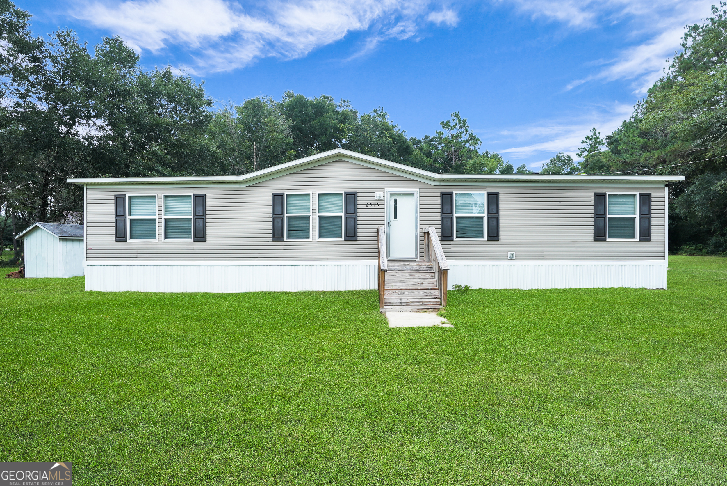Highly motivated Seller offering $5,000 towards closing costs!!! Located less than 10 minutes from the New Hyundai plant, I-16 and convenient to Pooler and Savannah, you'll definitely appreciate the perfect blend of country space and city accessibility that this stunning 2023 Clayton mobile home situated on 1.43 acres has to offer. With this home only being 2 yrs. old, you have the luxury of a 2 yr. old roof, 2yr. old kitchen appliances, a smart thermostat, and low-E insulated windows to name a few. It features an open concept floor plan that will satisfy anyone's wants and needs of what they are looking for in a home. The living area is spacious enough to accommodate family or guests for movie night while allowing visibility into the spacious kitchen that features the center island as the main attraction that is perfect for large family gatherings, entertaining, and making memories. Adjacent to the kitchen is the breakfast area where you can enjoy sipping your morning coffee or step out onto the back porch to enjoy the peaceful view of the expansive tree lined back yard. The split bedroom design offers a spacious primary bedroom with a huge walk-in closet and ensuite bathroom for privacy. There are 3 additional bedrooms and a guest bathroom with a porcelain sink on the other end making this home ideal for someone wanting peace and quiet, larger households, or multi-generational families wanting privacy. With the expansive backyard you are sure to enjoy the endless possibilities that it offers such as allowing you to add room for a workshop, garden, outdoor space for pets or kids, or any future additions that you may have in mind.