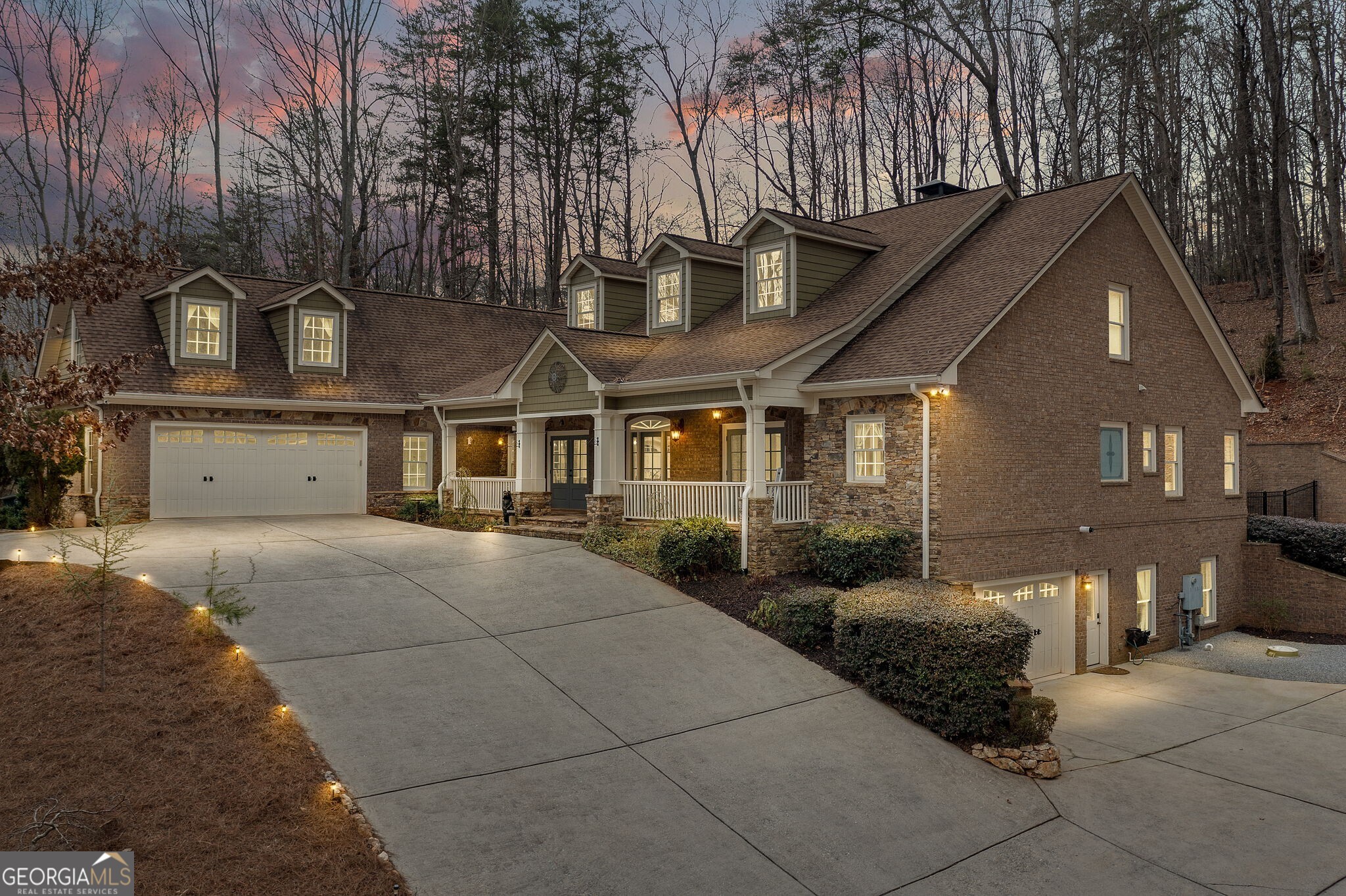 This 3.5 acre estate offers it all- ranch style home with a finished terrace level and a bonus room en-suite tucked away in gated neighborhood and private setting, all just 2.5 miles from Southern Living's top rated town, Dahlonega. Situated at the end of a long driveway, passing a babbling creek that runs along the property, you'll be welcomed home by a stone front porch and three sets of double doors that invite you inside. Inside, every room lends a spacious yet inviting setting to entertain and relax. Trim work adorns every room in the main living areas. Elevated coffered ceilings, stone to ceiling fireplace, and built in book cases create a sophisticated living room and offer a view to the spacious dining room, as well as direct access to the screened in porch for the perfect indoor-outdoor living floor plan. From the screened porch, enjoy the open air dining and grilling near the third fireplace and under the cafe lights, overlooking the courtyard with turf. Just off the living room, the fully renovated kitchen greets you with impressive quartz showcased as a countertop and integrated backsplash. The gas range is framed with glass cabinetry and a custom wood vent hood. This carefully designed kitchen offers convenience and luxury with an abundance of cabinetry and additional pantry storage. From the kitchen, a view of the second stacked stone fireplace brings your attention to the tongue and groove accented ceiling in the keeping room. The main level presents the primary en-suite, along with 4 bedrooms plus an office. The generously sized primary can accommodate a sitting area, and has a private entry to the screened in porch- perfect to enjoy morning coffee. The primary bathroom is sized for luxury and convenience, offering two vanities, a large tiled walk in shower, and a separate tub. The walk in closet features built in custom closet cabinetry. Across from the primary, there's a guest bedroom en-suite that offers private entrance to the front porch. The opposite wing of the main level has an additional 2 bedrooms with a shared en-suite bathroom, and a home office. The upstairs is solely dedicated to the bonus room with a full bath, perfect for guests or a flex space. The terrace level is designed with function in mind. The three car tandem garage is directly accessible from the lower level, along with its own driveway access. A media room is presented in addition to a living room, connected to the kitchenette with a fourth fireplace. Two additional bedrooms and a full bathroom are on the lower level. The central vac system, 5 car garage parking accommodations, ample storage throughout, and its location close to GA-400, Dawsonville and Dahlonega shopping & dining create a seamless blend of convenience and luxury.
