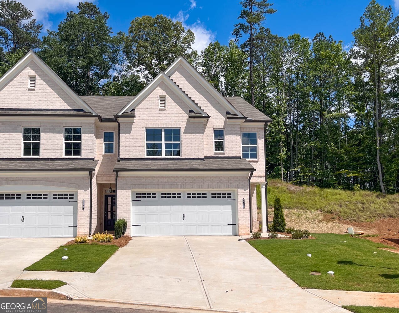 The Pinewood plan built by Southvine Homes is the last End Unit and Ready for Quick Move-In! This new townhome community is in a highly sought after Duluth location, walkable to historic downtown square to enjoy the festivals and endless dining and shopping options! This popular open concept floorplan is an End Unit on a premium homesite near amenity area and has the perfect flow of function and design, offering 3 spacious bedrooms/ 2.5 baths plus upstairs loft! The open dining area and large family room with modern electric fireplace complete with dramatic shiplap surround make for the perfect gathering spot leading out to the private covered rear porch to enjoy the beautiful surrounding woods. The entertainer's kitchen boasts upgraded white painted cabinets with stone counter tops, tile back splash, plus stainless steel appliances! Enjoy relaxing in your luxurious private primary suite flooded with natural light, boasting double trey ceilings and a massive walk-in closet. The spa-like primary bathroom offers a double vanity with quartz countertop, tile floor and shower with frameless glass door. Separating the primary suite and secondary bedrooms you'll find the open loft area perfect for home office, playroom, media room, or flex space . Generously sized secondary bedrooms, hall bath with quartz countertop and conveniently located laundry room complete the upstairs. Come and enjoy maintenance-free living complete with community pool and cabana and experience all this prime Duluth location has to offer, Walkable to Rogers Bridge Park, Chattapoochee Dog Park and close to several river recreation areas! The HOA dues are just $220/month and cover the amenity area, exterior maintenance of building and roof, lawn care, private road & street lights. Ask us about our specific incentive for this homesite of up to $10,000 toward closing costs with the use of our preferred lender with binding contract by 09/30/2025.