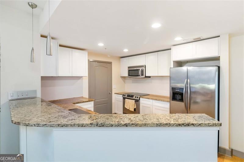 Experience stunning Atlanta skyline views from this gorgeous condo! This 4th-floor unit is ideally situated in one of the best locations within the building, offering both convenience and privacy. Enjoy secure, easy access from the gated parking garage with controlled entry. The spacious kitchen features granite countertops, stainless steel appliances, and a breakfast bar that opens to a bright, airy living room with floor-to-ceiling windows and captivating city views. The primary suite includes private balcony access, a generous walk-in closet, and a large en-suite bathroom with a soaking tub, separate shower, and double vanity. Washer and dryer are included, along with two deeded parking spaces and a private storage unit, adding exceptional value and convenience. Community amenities include a resort-style pool, fitness center, car wash station, gated parking, club house and dog park. Just a short stroll to top-tier shopping, dining, and entertainment - this one is truly a must-see!