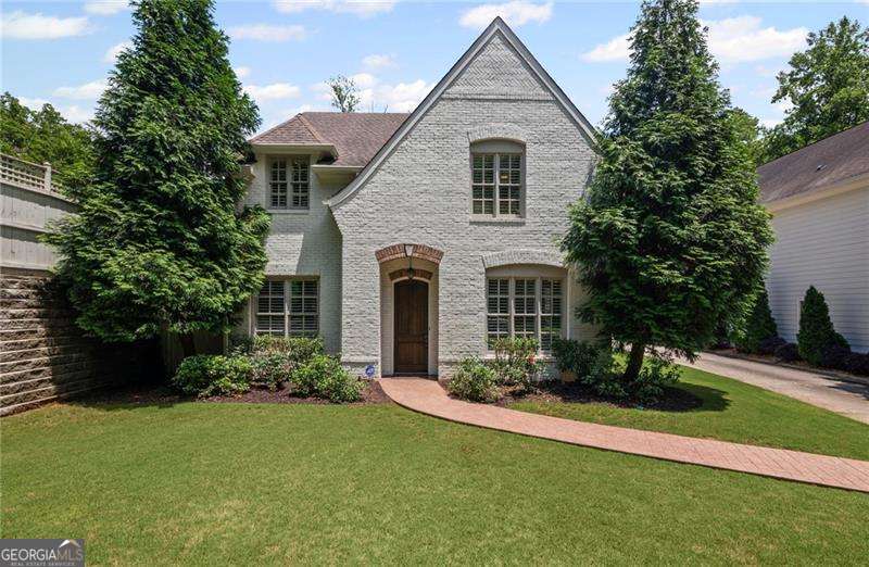 Steps from Smyrna Market Village - Luxury Living Meets Timeless Charm. This captivating home, just a stone's throw from the vibrant Smyrna Market Village, blends exquisite design with top-tier finishes for the ultimate in refined living. From the moment you step inside, you'll be greeted by arched doorways, plantation shutters, and elegant spaces tailored for both daily living and entertaining. The gourmet kitchen is a chef's dream, outfitted with a professional-grade Viking range, a spacious island, new crisp, white cabinets, quartz countertops and a well-appointed butler's pantry-perfect for hosting or everyday culinary adventures. A separate formal dining room and living room offer sophisticated entertaining spaces, while the cozy family room invites you in with a stunning stone fireplace and raised hearth. Upstairs, the oversized primary suite is a true retreat, featuring a serene sitting area that has been plumbed for a morning beverage bar, dual walk-in closets, and an opulent spa-inspired bath with a double-headed shower. Step out onto your private, covered screened-in porch and enjoy peaceful views of the beautifully landscaped backyard. The generously sized secondary bedrooms offer comfort and style that will exceed your expectations, with two having a custom, built-in window seat offering additional storage options. Outside, your personal oasis awaits. Entertain effortlessly on the covered stone patio with a built-in gas grill, enjoy some friendly competition on the putting green, or unwind beside the custom outdoor fireplace as the soothing sounds of the water feature create the perfect ambiance. The fully fenced yard offers privacy and serenity in equal measure. Luxury, comfort, and location-all perfectly combined in this exceptional Smyrna home.