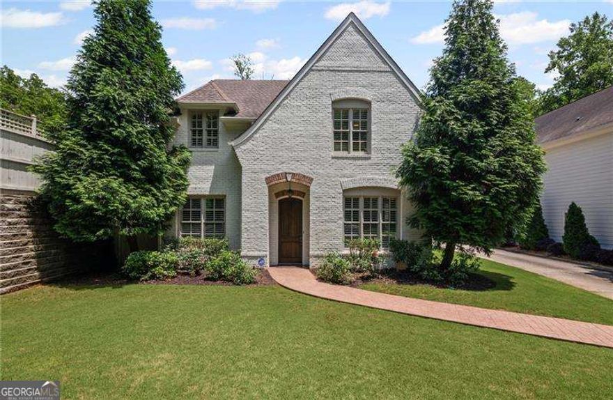 Steps from Smyrna Market Village - Luxury Living Meets Timeless Charm. This captivating home, just a stone's throw from the vibrant Smyrna Market Village, blends exquisite design with top-tier finishes for the ultimate in refined living. From the moment you step inside, you'll be greeted by arched doorways, plantation shutters, and elegant spaces tailored for both daily living and entertaining. The gourmet kitchen is a chef's dream, outfitted with a professional-grade Viking range, a spacious island, new crisp, white cabinets, quartz countertops and a well-appointed butler's pantry-perfect for hosting or everyday culinary adventures. A separate formal dining room and living room offer sophisticated entertaining spaces, while the cozy family room invites you in with a stunning stone fireplace and raised hearth. Upstairs, the oversized primary suite is a true retreat, featuring a serene sitting area that has been plumbed for a morning beverage bar, dual walk-in closets, and an opulent spa-inspired bath with a double-headed shower. Step out onto your private, covered screened-in porch and enjoy peaceful views of the beautifully landscaped backyard. The generously sized secondary bedrooms offer comfort and style that will exceed your expectations, with two having a custom, built-in window seat offering additional storage options. Outside, your personal oasis awaits. Entertain effortlessly on the covered stone patio with a built-in gas grill, enjoy some friendly competition on the putting green, or unwind beside the custom outdoor fireplace as the soothing sounds of the water feature create the perfect ambiance. The fully fenced yard offers privacy and serenity in equal measure. Luxury, comfort, and location-all perfectly combined in this exceptional Smyrna home.