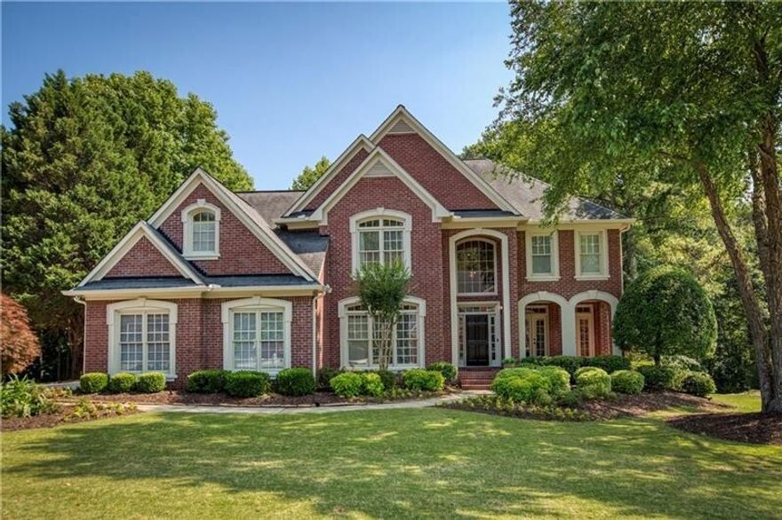 Luxury indoor and outdoor living awaits at this brick beauty in the desirable Johns Creek swim/tennis community of Hampton Hall! Made for entertaining, this home is light and bright featuring gleaming hardwoods on the main & upper level, neutral colors and updated light fixtures throughout. As you enter the two story foyer, you'll find a spacious home office and a formal living room with double doors that open to a rocking chair front porch. The gourmet chef's kitchen features white cabinetry, granite countertops, a 6-burner gas cooktop, an oversized island perfect for family gatherings and opens to the breakfast area and vaulted fireside great room with dual built-ins and a door that leads to the deck overlooking the private backyard. Retreat to the upstairs primary suite which offers an updated spa-like bath with a soaking tub, separate shower, dual vanities and a walk-in closet. In addition, there are three spacious secondary bedrooms - one with an ensuite bath and the other two with a shared jack-n-jill bath. It's game on in the finished terrace with a separate living area, wet bar with full size fridge, game room, bedroom and full bath. Step outside to your outdoor oasis. The generously sized deck with low maintenance trex decking  and under decking system provide the ideal spaces to enjoy views of the refreshing saltwater pool and hot tub with plenty of space to lounge. Enjoy roasting marshmallows around the firepit in the privacy of your own backyard! Hampton Hall is truly the best swim/tennis community in top rated Johns Creek HS district and has a variety of social activities including a swim team, family events, 4 tennis courts, tennis teams and a soccer field. Unbeatable location! Bike or walk to Big Creek Greenway and Waters Road park. Minutes to fun shopping, restaurants and nightlife in downtown Alpharetta, Avalon, Newtown Park, Ocee Park and more!
