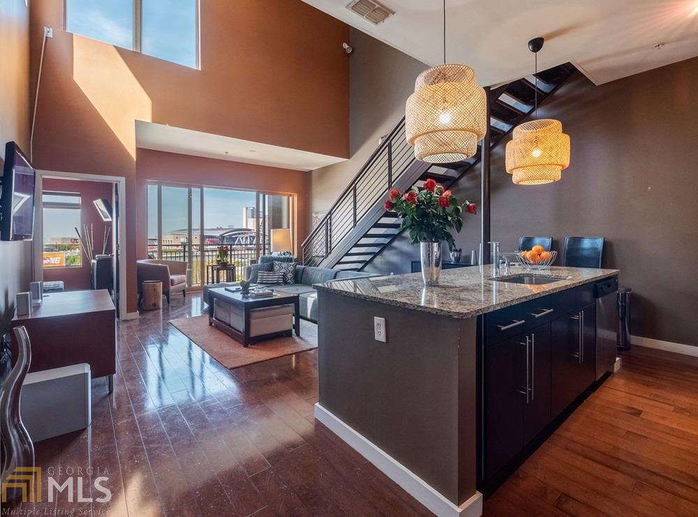 TOP FLOOR UNIT WITH A PERSONAL ROOFTOP PATIO & PRIVATE BALCONY! If you are after the best view of ATL, this is it! Hardwood floors, granite countertops, stainless steel appliances, and gorgeous light fixtures make this loft feel like a modern and classy home. Invite friends over and walk to the sporting events in the Mercedes Benz Stadium, or one of the many restaurants, bars, local shopping, and the amazing Art Stroll every second Friday this spring. Or just stay in and relax by the ROOFTOP POOL, clubhouse, or gym. This amazing floor plan is rarely available.