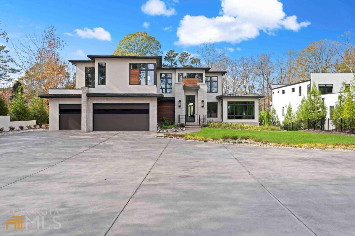 Feast your eyes upon the most magnificent modern estate in Buckhead! Extraordinarily designed, and custom built by Bella Fine Homes, this gated home boasts 5 beds, 5 full baths and 3 half baths, with an open concept floor plan featuring 20+ feet ceilings and gorgeous white oak hardwood flooring throughout. Floor-to-ceiling tinted windows offering boundless natural light, with automated shades for your privacy. Chef's kitchen with Miele appliances, built-in espresso machine and 4 range and steam ovens. Fully automated URC Smart Home Control and security system with cameras. 16 ft accordion doors that open to the ultimate resort style, astroturfed backyard oasis! Entertain with ease in your salt water, infinity-edged pool, covered fire pit, outdoor kitchen & grilling station w/beverage center and a pool bath. So many intricate fine interior details - Owner's suite on main w/separate sitting room which accesses the outdoor features. Custom his & her closets w/locking jewelry drawers, a luxurious owner's bath with floating vanities and heated floors. A spacious 2nd story open loft space, expansive secondary en suite bedrooms, Sonos audio system, in-wall Ipad controls, Lutron accent lighting, an elevator, and an exquisitely finished terrace level featuring an open recreation area, media room, styling salon, kitchenette, office suite, fitness room and sauna/steam shower. 3 car garage w/ electric car charging port and ample parking space. Easy access to all major highways, Atlanta's top-rated public and private schools, shopping and fine dining. This all-encompassing, contemporary dream home has it all!