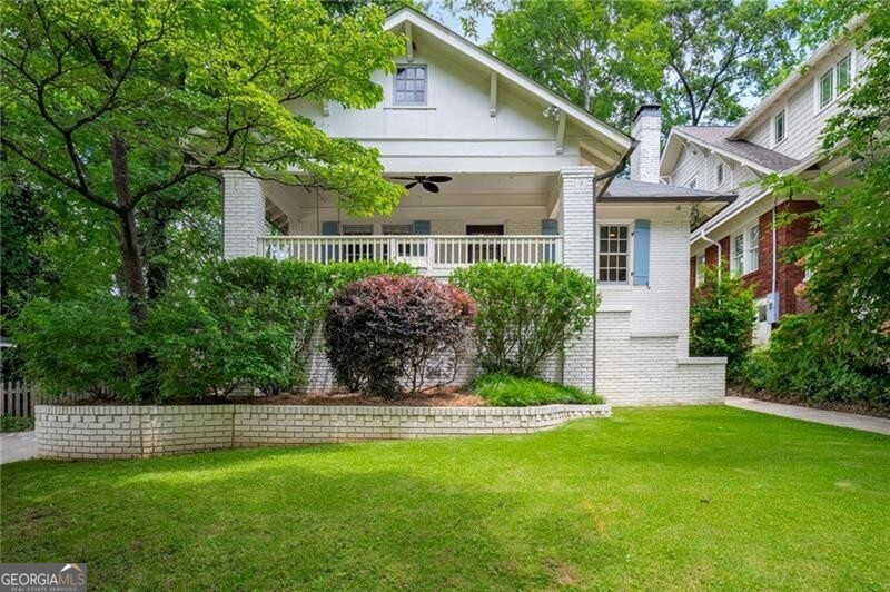 Perched above the best street in Virginia-Highland, this beautifully updated 1920s bungalow blending timeless historic charm with modern comfort. A classic rocking-chair front porch with views to the south welcomes you into a warm, light-filled interior with original hardwood floors, 10-foot ceilings, built-in cabinetry and a cozy fireplace. The separate dining room with oversized windows, designer lighting has room for eight to dine. The chef's kitchen is outfitted with ceiling-height shaker cabinets, quartz waterfall entertaining island, professional Jenn-Air appliances, porcelain farmhouse sink, and a dry bar that opens to an inviting covered outdoor living space with gas fireplace and bluestone patio. The spacious primary suite includes a spa-like bath with soaking tub and a divided walk-in closet. Two additional rooms offer flexible options for guests or offices. The fenced turfed backyard is private and low-maintenance, with extra storage in the basement and the "shed" (under the front porch). A full-height attic with permanent stairs offers exciting potential for future expansion. Just steps from Piedmont Park, the BeltLine, and all the shops and restaurants of Virginia-Highland and Midtown, this home is the perfect blend of character and convenience.