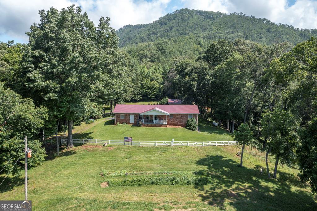 BIG MOUNTAIN VIEWS & A 2 STALL HORSE BARN!! This three bedroom/2 bathroom brick ranch home offers a screened in back porch, spacious front porch, living room with wood floors, open kitchen with dining area, fire pit area, pasture, barn, a garage space for parking plus detached workshop/garage. Basement is partially finished with second kitchen.