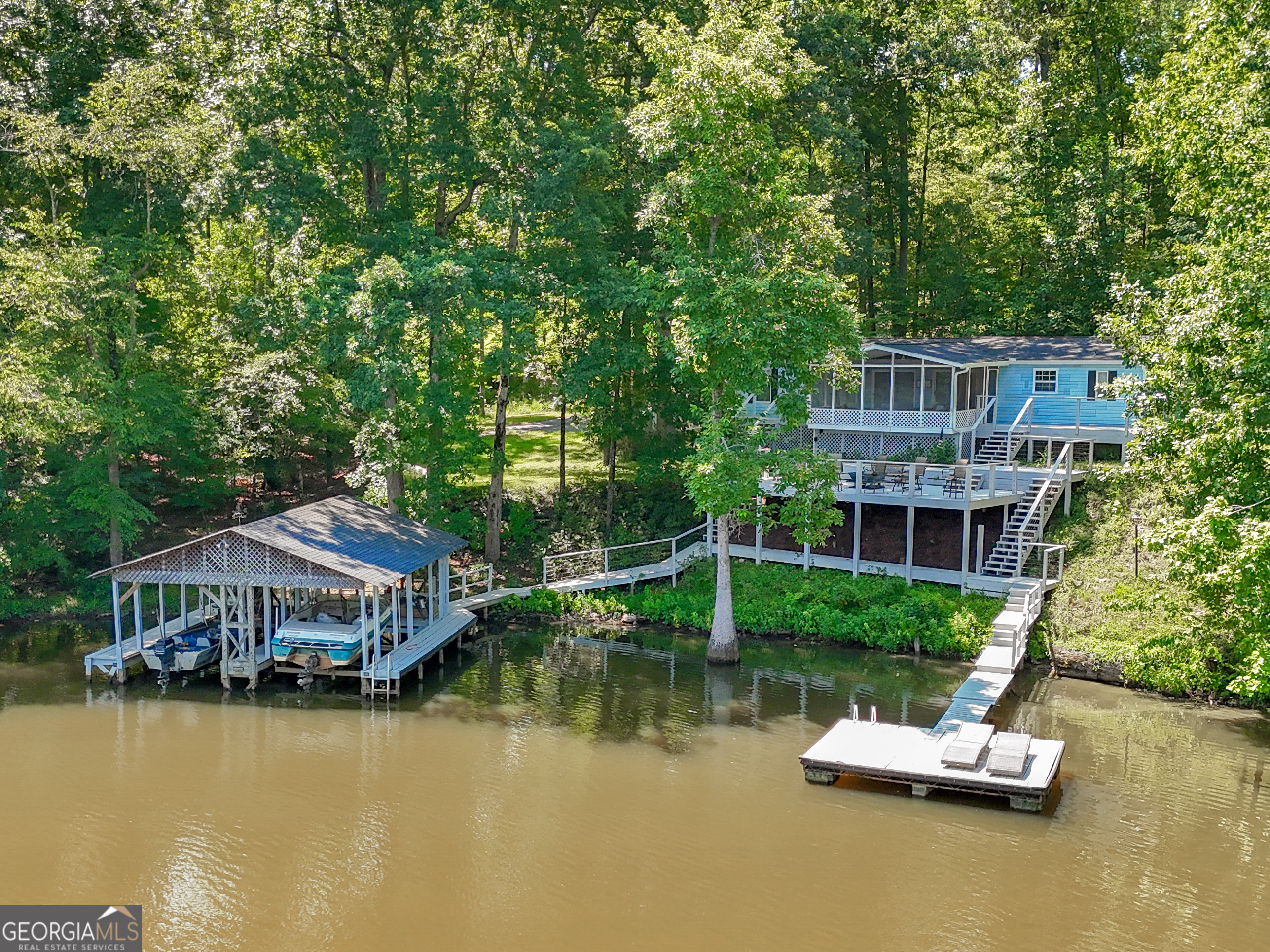 Welcome to your private retreat on beautiful Jackson Lake! Nestled on nearly 3 acres, this 3-bedroom, 3.5-bath home offers the perfect blend of peaceful seclusion and lakefront luxury. Step inside to an open-concept living area filled with natural light and panoramic lake views. The main level features a cozy living room with a stone fireplace, a newly renovated kitchen with granite countertops, stainless steel appliances and a kitchen island that is perfect for entertaining. Each of the three oversized bedrooms are designed with comfort in mind, offering ample space for relaxation, while the three and a half large bathrooms provide plenty of room for guests and family alike. Step outside to the screened in porch, expansive deck, and easy access to the lake. A floating dock, boat dock with 2 boat lifts and a jet ski lift are among the many things to enjoy! Home is being sold fully furnished and boat and jet ski are also included. With almost 3 acres, there's plenty of room for outdoor fun, gardening, or future expansion. Whether you're looking for a full-time residence, weekend getaway, or vacation rental opportunity, this Jackson Lake gem is ready to welcome you home. Don't miss this rare chance to own a slice of lakefront paradise!