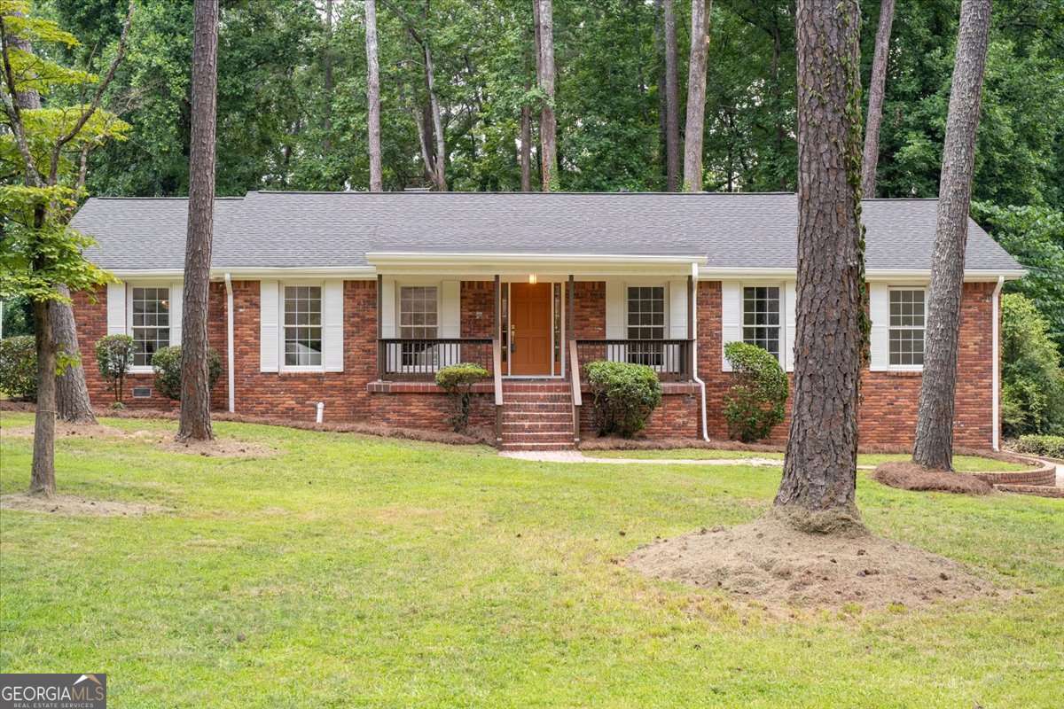 A beautifully renovated ranch in one of Southwest Atlanta's most nature-rich, connected, and quietly coveted pockets. Located just minutes from Cascade Springs Nature Preserve, Lionel Hampton Park, and the BeltLine's Westside Trail, this home offers rare access to hiking trails, biking paths, and lush green space - while still being less than 15 minutes from Downtown Atlanta, Hartsfield-Jackson Airport, and I-285. Whether you're commuting, traveling, or simply seeking the balance of convenience and calm, this location delivers on every front. Step inside to discover a light-filled interior where comfort meets thoughtful updates. The generously sized living room flows into a separate dining area, creating the perfect layout for both daily living and entertaining. The family room features charming beamed ceilings, chair rail accents, a cozy fireplace, and a custom built-in, offering warmth and personality. The renovated kitchen is equipped with white cabinetry, quartz countertops, stainless steel appliances, upgraded backsplash, updated fixtures, pantry, and a sunny breakfast nook for casual meals. The oversized primary suite is a true retreat, complete with a walk-in closet, stylish barn door, and a fully updated en suite bath featuring a new vanity, lighting, and tile shower. Two additional well-sized bedrooms and a fully renovated hall bath offer flexible space for guests, hobbies, or work-from-home needs. A spacious laundry room with a sink, countertop space, and built-in cabinetry adds function and flow, while the partial basement includes a half bath and a 2-car drive-under garage for storage and convenience. Out back, unwind in the expansive screened-in/covered porch or enjoy the separate patio area, all overlooking a private, tree-lined backyard - perfect for entertaining, quiet mornings, or summer evenings under the stars. With its prime location, thoughtful upgrades, and indoor-outdoor lifestyle appeal, 761 Lynn Circle SW is the perfect blend of classic comfort and modern convenience in the heart of Southwest Atlanta.