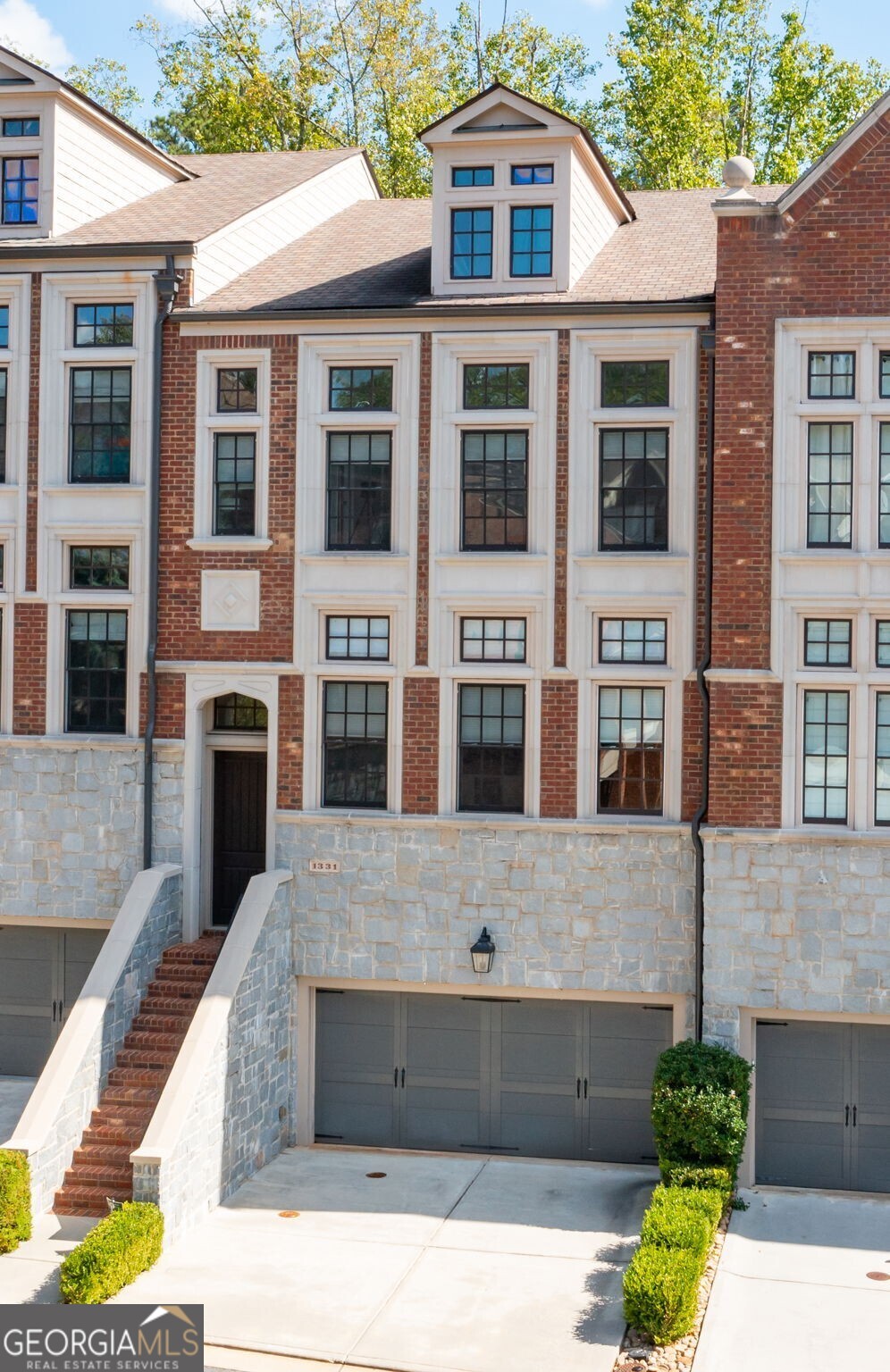 Modern luxury meets timeless Brookhaven charm in this striking 4-story townhome within the gated Savoy at Town Brookhaven community! Designed by Ashton Woods, this residence blends sophisticated design with a true walk-everywhere lifestyle - just steps from the vibrant Town Brookhaven district. The terrace level offers a full suite currently used as a glam room with sitting area, full bath, and walkout patio. The second floor features a guest bedroom with twin closets, full bath, additional living space, and a private covered deck. The main level showcases a show-stopping kitchen with JENN-AIR appliances, a massive island, microwave drawer, built-in refrigerator with custom cabinetry, walk-in pantry, and detailed millwork - opening to a fireside family room with built-ins, abundant natural light, an additional sitting area, and another covered deck perfect for entertaining. The top floor hosts an additional bedroom suite, office nook, laundry room, and an oversized primary retreat with a luxury spa-inspired bath featuring a soaking tub, tiled shower with dual shower heads, water closet, and custom walk-in closet. Soaring ceilings, elegant designer fixtures, hardwood floors, and a built-in speaker/intercom system elevate every level. HOA includes exterior dwelling maintenance, landscaping, and resort-style pool with outdoor fireplace and grilling area just across the street. Ideally located adjacent to Town Brookhaven, a lively destination for dining, shopping, and entertainment, and just minutes to additional local hubs and parks offering endless outdoor recreation, community events, and green spaces. Convenient to the Brookhaven/Oglethorpe MARTA station with quick access to Buckhead, Midtown, and Perimeter, all within the top-rated Chamblee Charter school cluster. Experience the best of Brookhaven - where modern convenience, walkable living, and gated serenity meets an energetic, connected community!
