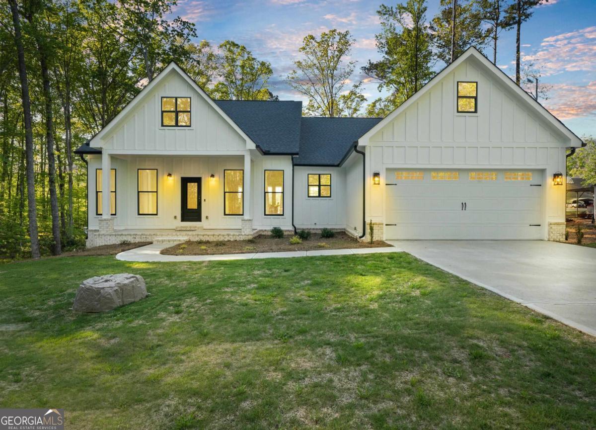 Welcome to "Forever Stay on Lake Sinclair". This 4/3 ranch is located in Holiday Shores and is sold turn key/completely furnished. The home was built in 2022 and the terrace level was finished in 2024. The home boasts high end finishes throughout and sits on a point lot with incredible main lake views. Open plan with LPV flooring throughout the main level. Chef inspired kitchen with walk in pantry. Quartz counter tops throughout. High end appliances with a Z Line gas range. Electric fireplace with wooden accents. Master suite on main. Bunk room plus an additional guest room are located on main floor. Screened porch. Theater room. Game room. Firepit. Putting green. 2 car garage. Private dock with slip. Too many extras to list. Holiday Shores amenities include: Boat ramp, common dock, playground, basketball/volleyball/pickle ball courts, pavilion, firepit, community center with fitness equipment, volunteer fire dept with an emergency helipad. Air medivac insurance is $85/family/year. Property is used as a short term rental and shown by appointment only.