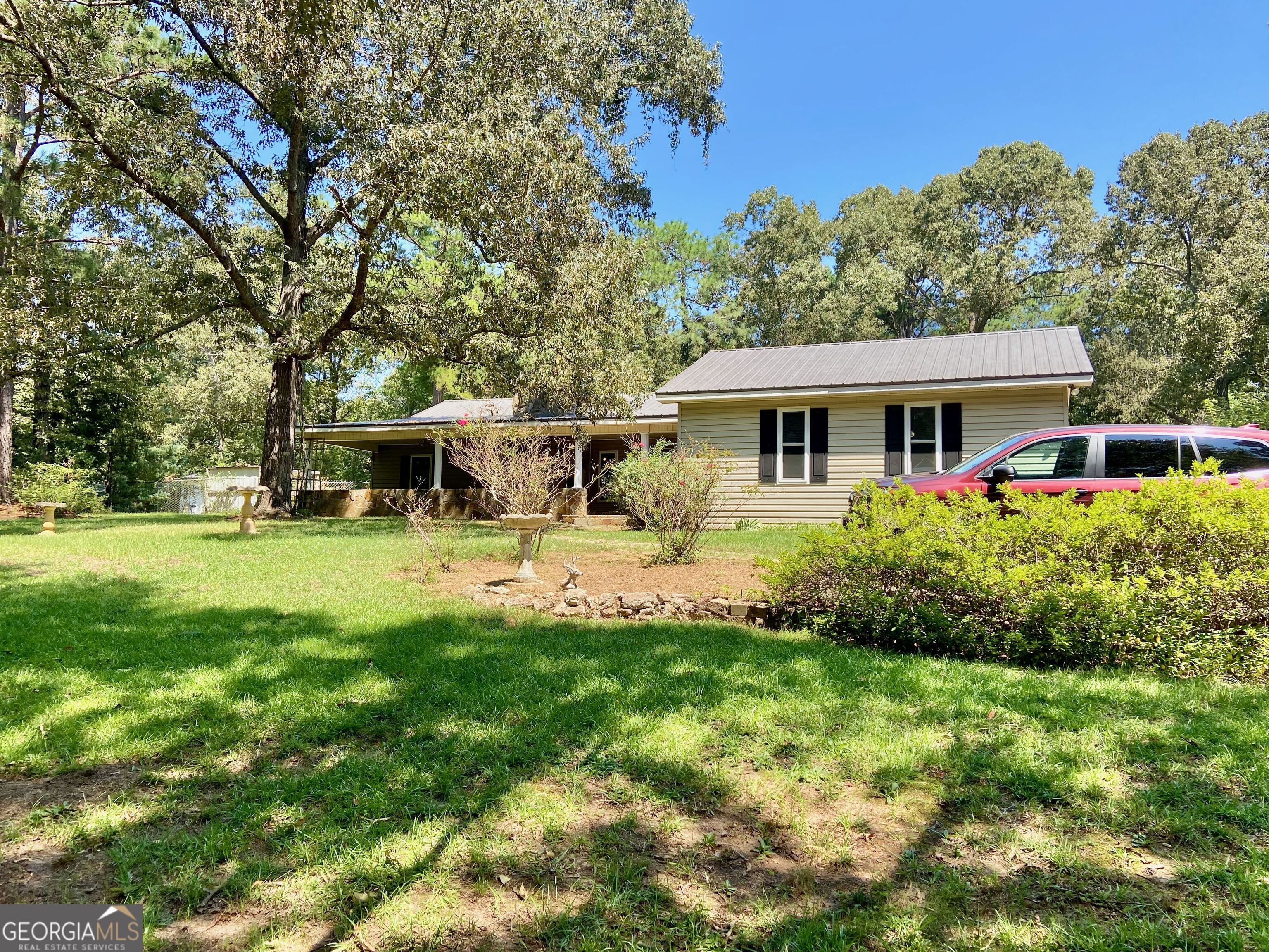 Check out this 1978 gem - a 3-bedroom, 2-bath home on a 1-acre lot, perfect for garden enthusiasts! The property has been beautifully maintained and updated, featuring a large covered front porch for spring relaxation, a sunroom for summer lounging, and a cozy fireplace for winter warmth. The yard boasts arbors, a pergola, two water features, statues, mature landscaping, and a spacious patio, ideal for outdoor entertaining or private enjoyment.