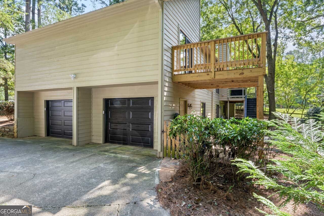 Welcome home! This stunning 4-bedroom residence is nestled on a beautifully wooded lot, surrounded by lush landscaping that offers both privacy and tranquility. As you step inside, you'll immediately be greeted by an open concept layout that allows for seamless flow and abundant natural light. The heart of the home features vaulted ceilings and skylights in both the kitchen and bath, enhancing the airy feel of the space. The kitchen boasts modern finishes, perfect for both cooking and entertaining. Relax in the spacious living area or enjoy family meals in the dining nook, all while soaking in the views of your serene backyard through generous windows. Retreat to the luxurious master suite, complete with its own private bath and ample closet space, and a private deck, while an additional 2 bedrooms provide comfort and versatility for family, guests, or a home office. The fully finished basement offers endless possibilities with its cozy sitting area, full bath, new luxury vinyl flooring and an additional bedroom-ideal for hosting visitors or creating a space for a roommate or in-law suite. The basement offers a second laundry room for extra convenience. Outdoor enthusiasts will love the fenced backyard, perfect for pets and play, and the beautiful balcony that overlooks the vibrant landscape, making it the perfect spot to unwind with a book or share a meal under the stars. The large workshop provides space for hobbies, DIY projects, or extra storage. With ample storage in the spacious 2-car garage, this home offers the perfect blend of comfort, style, and functionality. Located in a picturesque community, you'll enjoy friendly neighbors, just minutes from The Forum, Award-winning schools, YMCA and Simpsonwood Park.