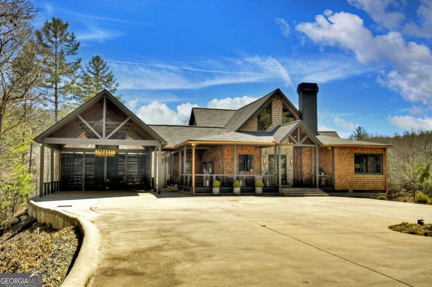 Calling all outdoor enthusiasts! Welcome to your own contemporary rustic compound sitting on sixty +/- acres and adjoining US National Forest! With modern luxuries and mountain charm, this sprawling lodge is complete with four bedroom suites, two additional bunk areas, a large office overlooking the lush rolling meadow, and gorgeous Carrera marble bathroom ensuites. Sleek accents combine with painted tongue and groove walls and ceilings, rough sawn cabinetry, and walls of glass to create the perfect blend of modern and rustic finishes. Main level living room is centered around large stone F/P, gourmet kitchen, butler's pantry and stunning eat-in island. Off the main, find an 1,110 sq. ft. bespoke party porch w/ 24' rooflines, large masonry F/P, and gourmet outdoor kitchen. Terrace level den opens up to large stone patio and heated pool w/ jacuzzi overlooking lush meadow, stocked pond, and complete privacy. Full entertainer's bar is accessed from pool deck w/ full drink cooler and pool house kitchen. At top of property, find an original hunter's blind turned outdoor party pavilion with 180 degree mountain views, massive fire pit, and half bath. Also includes an unfinished 4,000 sq. ft. barn w/ power and plumbing, two small pole barns, and a three bay car barn. Fully gated, equipped w/ a whole house generator and with a roaring creek that runs throughout the property and with numerous potential home sites, this would make for the perfect mountain retreat, investor's project, or rental investment!