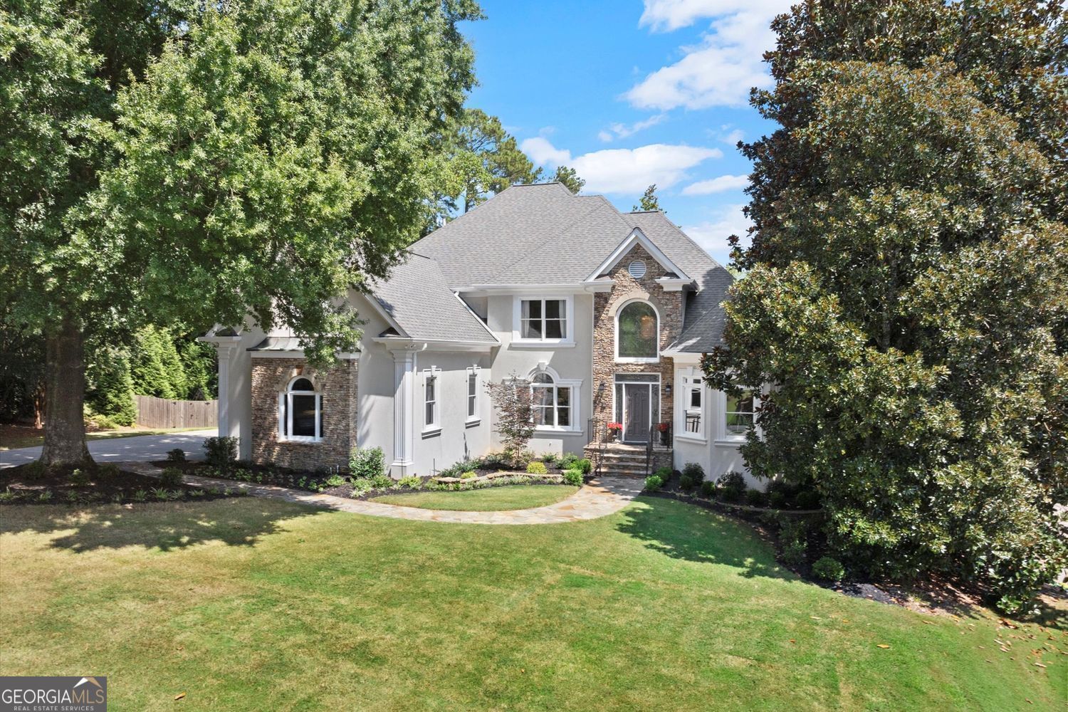 Sometimes a home just feels meant to be and this PRIMARY ON MAIN Executive Home w/NEW POOL tucked into the Meadows section of Seven Oaks, welcomes you home with warmth, sophistication and luxury. For larger families or extended guest stays, a true In-Law Suite with a FULL KITCHEN on the Terrace Level makes this home the easy choice. Relaxation is paramount as this gorgeous home offers a recently added sparkling Saltwater Pool & Spa surrounded by lush landscaping, tall pines and year round breezes on the Screened-in Porch. The curved staircase, NEWLY refinished hardwood flooring, neutral hues and paint refreshes instantly set the tone for what awaits in this immaculately kept and move-in ready home. The warm-hued hardwoods, soaring ceilings, plentiful architectural details and abundant natural light throughout all add to this home's ambiance. Details such as wainscoting, trey ceilings, pocket doors and handy access to the Butler's Pantry all enhance the oversized formal Dining Room's appeal. A formal Living Room with vaulted ceilings has French doors which allow for privacy and adds flexibility for a home office option. Enjoy FIRST FLOOR Living with your Primary Suite on the main! Bayed windows, and trey ceilings adorn this oversized owner's bedroom along with an ensuite that features tile flooring, granite counters and a whirlpool tub. The spacious owner's closet has been smartly designed with custom cabinetry. The 2-story Great Room is anchored with a cozy fireplace flanked by built-in mirrored bookshelves and features a wall of windows streaming in natural light and new chandelier, adding a touch of elegance to this space. Step into the Kitchen/Keeping Room to find a space that will no doubt be the center of family gatherings. In this chef's kitchen, plenty of storage is found in the warm honey toned wood cabinets; including both sides of the granite topped peninsula island. Keep your dishes and food prep separate with handy DUAL kitchen sinks! Enjoy preparing family meals and then serve it up in the bright and light breakfast area overlooking the serene backyard. At tea time, an instant hot water dispenser allows a quick steep, as you then relax and unwind in the cozy Keeping Room anchored with a floor-to-ceiling stacked stone fireplace, extra cabinetry and skylight windows allowing in even more natural light. Convenient Laundry room and rear stairs on this level. Upstairs, find three generously sized bedrooms and two full bathrooms. One bedroom is MASSIVE with an attached flex space making it an ideal teen suite, study lounge, or game/media room. The breezy Screened Porch and newly EXTENDED rear deck allow for year-round outdoor enjoyment and panoramic views of your PRIVATE and lush backyard oasis. Glistening waters reveal a *2 YEARS NEW* voluminous Saltwater Pool w/ Waterfall Spa all in a "Pebble Sheen" finish for added luxury! Plenty of lush lawn space allows for other outdoor activities and shady side decking offers more space to entertain or watch the kids play. This backyard truly has something for everyone! The daylight Terrace Level is a true extension of the upper floors with 2 spacious bedrooms, a full bath, cozy and inviting living room, a full Kitchen w/pantry, W/D and Media Room - the perfect in-law suite! And, with versatile tile flooring - easy access to the pool and patio makes this the ideal place to come in from a swim or outdoor fun. Unfinished areas provide great storage opportunities as well. Seven Oaks is a well-established active neighborhood located in the highly desired Northview HS district and is replete with amenities including: swim and tennis, sport court, soccer fields, playgrounds, pickle ball, clubhouse w/gym, a lake, green space w/walking trails and year round events. LOCATION LOCATION: The new "Medley Johns Creek" opens Fall 2026 and will offer plentiful shopping and dining options less than 2 miles away! Your perfect home awaits, schedule a tour today!