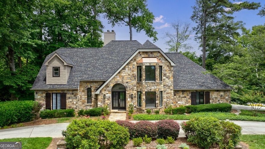 Prepare to be enchanted by this storybook stone estate, a true masterpiece nestled directly across from the prestigious Atlanta Country Club. Renovated down to the studs with all-new systems including a new roof, new electrical, and modern HVAC, this home blends timeless architectural charm with luxurious contemporary finishes-making it as comfortable as it is cinematic. The arched front door entry and curved stone exterior create a dramatic first impression, while inside, a chic foyer with wrought iron accents leads you into a completely reimagined open-concept floorplan filled with natural light. The chef's kitchen features white cabinetry, granite countertops, and top-of-the-line stainless steel appliances, all opening into a stunning family room with fireplace, designer feature wall, and breathtaking views of the manicured grounds and arched Screen in Oversize room. The formal dining room offers front-row views of the Atlanta Country Club's fairways, while a den with custom built-ins and wet bar overlooks the serene, private yard. A spacious main-level guest suite with full bath adds flexibility for multigenerational living or luxurious guest accommodations. Upstairs, the oversized primary suite is a retreat unto itself-complete with fireplace, a private rooftop balcony, spa-inspired bathroom with soaking tub, glass-enclosed shower, dual vanities, and a massive walk-in closet with its own laundry-a rare and coveted feature. Two additional upstairs bedrooms are outfitted with designer tile baths and quartz countertops. The finished terrace level is a destination all its own, offering a stylish recreation room, kitchenette, full bedroom and bath, a sleek wine wall, and a refined half bath for guests. Outside, a covered lanai with a charming swing to enjoy the peaceful garden area, while the loggia provides a beautiful walk-out to the expansive, grassy side yard-ideal for entertaining, play, or even filming. With its distinctive aesthetic and expansive, light-filled rooms, this home is an ideal location for movie or television productions. Situated on a coveted corner lot in a cul-de-sac, this estate also includes a circular driveway, two-car side entry garage, and a dedicated golf cart pathway with its own covered parking. Zoned for Cobb County's most desirable schools-Sope Creek Elementary, Dickerson Middle, and Walton High-this home offers the pinnacle of East Cobb living. This is not just a rental-it's a lifestyle.