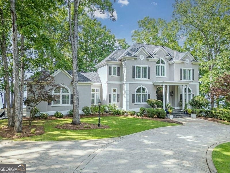 Elegantly casual perfectly describes this outstanding lakefront home, privately nestled on over an acre of gorgeous Lake Oconee shoreline with 450ft. of masonry seawall & 13ft of water at the dock . Within the gated community of Great Waters at Reynolds Lake Oconee, the owners have meticulously updated this home from top to bottom, inside and out. With expansive views throughout, your family will experience the finest Lake Oconee has to offer. From the moment you enter the circular drive, enter the beautiful foyer, lake vistas surround you. This gracious home offers multiple living areas, 6 bedrooms (5 with en-suite), a gourmet kitchen any chef would love and a 2nd kitchen on the terrace level. The main floor great room has windows galore, fireplace, built-ins, coffered ceiling and opens to the amazing kitchen with a 6 burner gas full range w/ custom commercial grade St. Udio vent hood, pot filler & convection double ovens. An 11 ft island with farm sink, custom cabinetry, quartz counters, ice maker and pantry. This open floor plan has a large lakeside dining area that opens to a large deck for outside dining and relaxing. Escape to the large main floor owner suite, again with spectacular views, fireplace, sitting area, custom automatic blinds & his & her custom closets. Owners bath is spa quality w/ a Victoria & Albert free standing volcanic limestone soaking tub, dual zone 6 head shower including a rain shower feature & 2 massage heads, quartz counters, Italian chandelier & custom cabinetry. A second large guest room on the main level accesses a bath directly. There is a main floor laundry & access to a 3 car garage. The upstairs is a guests paradise, 180 degree lake views w/ automatic blinds, rec-room, full bath, kitchenette with sink, mini fridge & bar. The 2 oversized upstairs bedrooms have private baths w/ dual sinks, soaker tubs & separate showers. The terrace level offers lots of options, with a 3rd large family/game room, a 2nd complete kitchen, 2 bedrooms (1 with en-suite) and additional bath + storage. And lake views from everywhere! Sonos smart surround sound system throughout the entire house, lakeside, patio and porch. Remodel completed 2021-2023 and includes all new plumbing, electrical, flooring, painting (outside painted in 2024), an additional HVAC system added 2022, zoned heating & air. Decking was replaced 2023, new upgraded max dock with 6100lb hydrolic lift, 2 jet ski lifts & Lumitec lighting. New landscape & lighting.