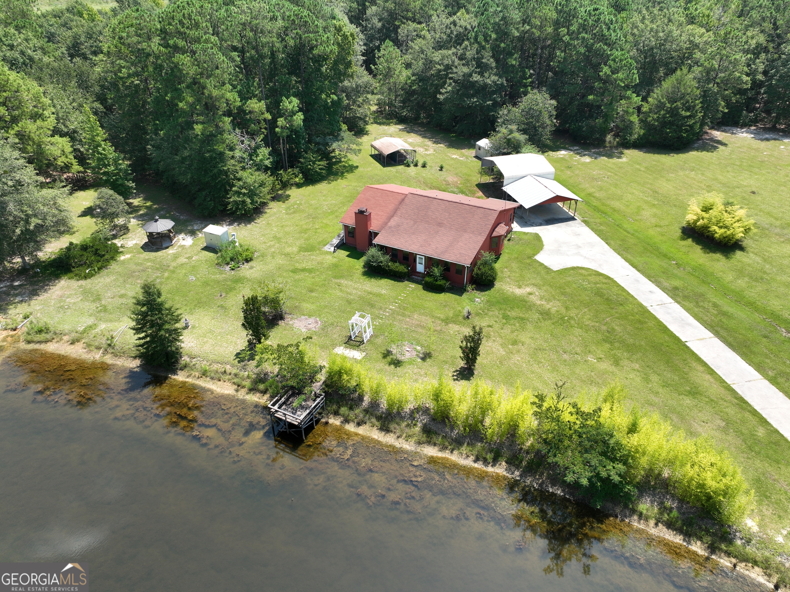 Welcome to your private retreat on 8 fully fenced acres-complete with a gated entrance, pond, and peaceful country setting -- but just minutes from the heart of town! This spacious 3-bedroom, 3-bath, 2544 sqft. home offers generous living spaces both inside and out. The large living room is perfect for gatherings, while the oversized primary suite includes a cozy sitting area with fireplace, tiled bath, large walk-in closet, and private exterior access. There is a second bedroom that could serve as another master bedroom --features its own large bath and walk-in closet. Down the hall is a flexible bonus room can serve as an office, craft room, playroom, or even a 4th bedroom. Enjoy the charm of country living with practical features like a mudroom, enclosed front porch, multiple metal carports and sheds, and a gazebo overlooking the pond. Surrounded by mature trees and abundant wildlife, this secluded home sits at the end of a quiet dead-end road-yet you're just outside the city limits with quick access to restaurants, shopping, and medical facilities. While some areas may welcome your personal touch, the potential here is outstanding. Whether you're looking for space to spread out, a place for animals, or simply room to breathe, this one checks all the boxes.