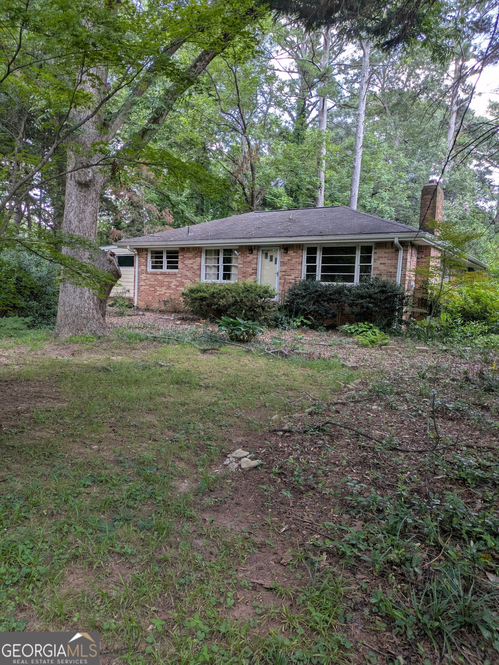 This home needs a complete rehab. It is on a very beautiful large .86 acre level lot with mature trees and sits way back from the road. The backyard is overgrown but used to have nature trails going through. The original brick 2BR 1 bath structure appears to be solid. The roof is estimated to be 12 years old. Original hardwood floors. There have been some additions over the years that need some help. It is on a septic tank rated for 3 BR according to the Seller. Sewer is available at the street. The value is in the large level lot. Bring your contractor/builder to come check it out. Tucker is BOOMING!