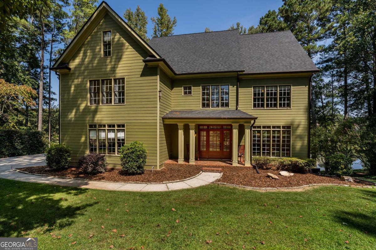 The location everyone is looking for...Cherokee County, but so close to Milton! The Red Gate Lakes community is a sought after neighborhood in premium location. 200 Red Gate Terrace is perfectly positioned right on the lake, with spectacular views and lengthy lake frontage. This traditional two-story home has been lovingly maintained and is ready for its next owners. You'll love the 2+ acre lot in this no-HOA community. Zoned AG, so you can bring those chickens! There's even a coop in place for you. A rocking-chair front porch greets you as you enter this unique property. The open foyer houses one of two staircases in this spacious home. The main level also boasts a formal dining room that seats 12+, an office (currently used as a piano room), a vaulted great room with cozy fireplace, and a spectacular mid-century modern kitchen with cabinets imported from Europe. Heading upstairs you'll find four bedrooms and three full baths. The primary ensuite is oversized and has his and hers closets. The secondary bedrooms are each generously sized as well, with plenty of closet space. The terrace level of this amazing home is fully finished with a walk-out patio to the lake and fire pit. It also features a movie room, bar area, game room, and newly remodeled full bath. With an entire wall of windows, this space is bright and functional. This home offers charm, premium location, a lovely community, and plenty of privacy. Schedule your appointment to see this unique gem today!