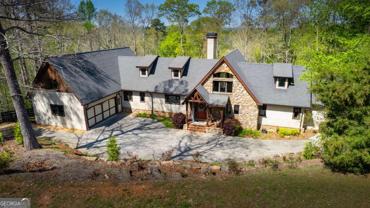 Nestled on over 2 PRIVATE, WOODED ACRES with an option to purchase an additional 2+ acre parcel to expand this GORGEOUS ESTATE. Located in Forsyth County's exclusive ETOWAH TRAILS with DIRECT TRAIL ACCESS to the ETOWAH RIVER and LONG-RANGE VIEWS of the NORTH GEORGIA MOUNTAINS, this EXQUISITE CUSTOM TIMBER FRAME home is PRICED WELL BELOW APPRAISED VALUE! Conveniently located minutes from BALL GROUND, CUMMING, POOLE'S MILL PARK, GIBBS GARDENS, and MORE!! Conveniently located minutes from BALL GROUND, CUMMING, POOLE'S MILL PARK, GIBBS GARDENS, and MORE! Designed by MILL CREEK POST and BEAM, the home features SOARING VAULTED CEILINGS, WIDE-PLANK PINE FLOORS, HANDCRAFTED IRONWORK, and MASSIVE EXPOSED BEAMS. The EXPANSIVE GREAT ROOM features a TWO-SIDED STONE FIREPLACE and GORGEOUS WALL-TO-WALL WINDOWS which showcase the river valley and North Georgia Mountain view. Fine finishes include TONGUE AND GROOVE CEILINGS, SOLID ALDERWOOD DOORS, EXQUISITE IRON DETAILS, and many more. Designed for energy efficiency and built to last centuries, the home is enclosed in STRUCTURAL INSULATED PANELS, which provide high R-Values and LOW energy bills. The cost to build this home today is well over 2M. The heart of the home is the GOURMET KITCHEN, with an 8-foot island and tons of cabinet space. Designed with the family chef in mind, high-end GE MONOGRAM appliances, GRANITE countertops, a SIX-BURNER cooktop, WARMING DRAWER, ADVANTIUM SPEED COOK OVEN, and GORGEOUS WALK-IN PANTRY will make cooking a joy. The OVERSIZED DINING AREA, also centered around the FIREPLACE, offers the PERFECT SPACE FOR ENTERTAINING with a fire and a view! Designed for ranch living, the MAIN-LEVEL PRIMARY SUITE features PRIVATE DECK ACCESS, a SPA-INSPIRED BATHROOM, and a CUSTOM WALK-IN CLOSET. Two additional main-floor bedrooms share a JACK-AND-JILL bath. A half bath and a LARGE LAUNDRY ROOM with BUILT-INS complete the main floor. At one end, a LOFTED OFFICE or COZY READING SPACE overlooks the GREAT ROOM. In contrast, at the other end of the house, a PRIVATE SUITE with a LUXURY BATH, WALK-IN CLOSET, and EXPANSIVE BONUS ROOM offers FLEXIBILITY as a FIFTH BEDROOM or BONUS ENTERTAINMENT SPACE. The nearly 3,000 SQ FT UNFINISHED BASEMENT is already INSULATED and FRAMED with a FIREPLACE INSERT, offering ENDLESS POTENTIAL for CUSTOMIZATION. Outdoors, enjoy 900 SQUARE FEET OF DECKING, a FENCED PADDOCK for dogs or ponies, and SERENE NATURAL SURROUNDINGS with direct access to the community WALKING and EQUESTRIAN TRAILS along the ETOWAH RIVER. Additional features include an OVERSIZED 750+ SQ FT GARAGE, COPPER GUTTERS, TANKLESS WATER HEATER, and PELLA ARCHITECTURAL DOUBLE-PANE CASEMENT windows with wide overhangs. Zoned for TOP-RATED FORSYTH COUNTY SCHOOLS and eligible for the FORSYTH COUNTY SENIOR TAX EXEMPTION, this home perfectly combines PRIVACY, the TRANQUILITY OF NATURE and LUXURIOUS LIVING close to MODERN CONVENIENCES. This is your OPPORTUNITY to OWN a TRUE NORTH GEORGIA MASTERPIECE. This quality of home doesn't come on the market very often! SCHEDULE YOUR PRIVATE SHOWING TODAY!!!