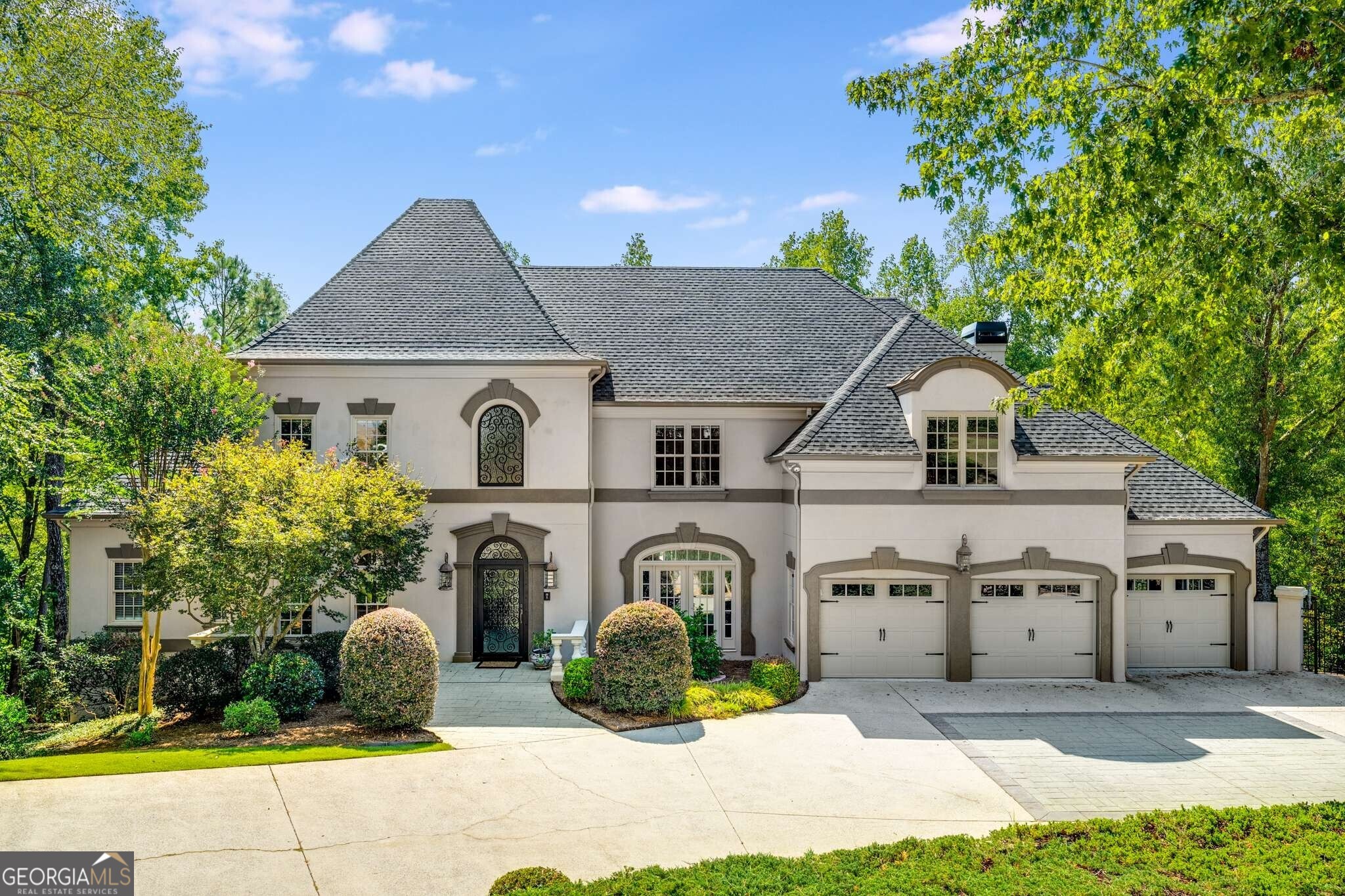 NEW ARCHITECTURAL ROOF, complete GUTTER SYSTEM and custom dome just installed! A rare opportunity to own a one-of-a-kind French Provincial estate, nestled on a private and exclusive street in Sandy Springs. Surrounded by multi-million-dollar homes, this Hardcoat stucco residence offers over 2.2 acres of ultimate privacy and refined luxury. An impressive iron door and staircase with a beautiful marble floor entry, set the tone for the home's sophisticated design. Hardwood floors flow throughout the light-filled interior, where exquisite millwork and custom architectural details elevate every space. Off of the foyer, there is a dedicated office with coffered ceilings and separate dining room with judges paneling and custom inlay detail. The formal living room includes built-in bookcases and a butler's pantry with wine storage, sink, and access to the back deck. The fireside keeping room and expansive chef's kitchen-featuring stone countertops, custom cabinetry, wine fridge, dual ovens, and newer SS cooktop and refrigerator are ideal for both gatherings and entertaining. The main level also features a spacious owner's suite, complete with a fireplace and sitting area, renovated travertine bathroom and separate closets. Upstairs you'll find five generous sized bedrooms and three renovated bathrooms. The fully finished terrace level is a true retreat, boasting an in-law suite, home gym, 1 full and 1 half bath, storage, cedar closet, a game room(pool table remains), and more. Oversized turnaround driveway in the front and three car garage with epoxy floor. Enjoy seamless indoor-outdoor living with a screened-in porch with fireplace. Two large decks that overlook the expanded backyard with sweeping views. Additional amenities include a whole-home generator, temperature-controlled storage shed, several newer windows and updated systems. Proximity to both public and private schools, major highways, and Dunwoody Country Club.