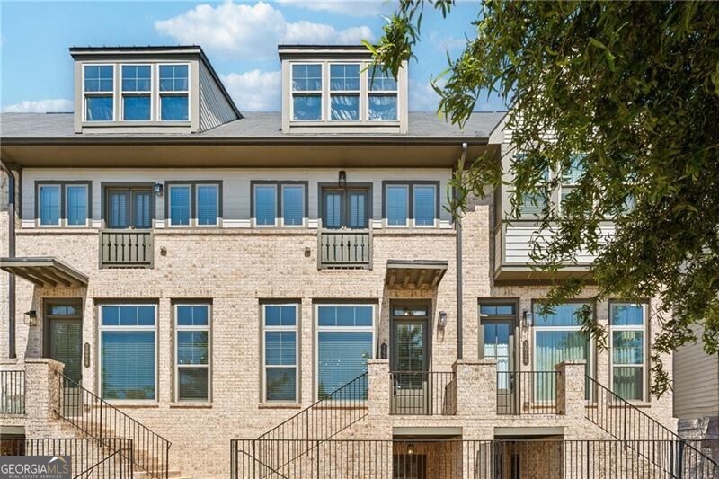 A stunning townhome in the heart of Vinings! Modern, light-filled living spaces feature an open floor plan perfect for entertaining, with high ceilings and designer finishes throughout.  Chef's kitchen with quartz countertops, large island, and stainless-steel appliances opens to a spacious living room and balcony.  The primary suite offers a spa-like bath and generous walk-in closet.  Secondary bedroom with en-suite bath provides the perfect guest retreat or home office.  Lower-level bedroom and full bath make for ideal additional guest room or home office.  Located in the gated community of Reverie on Cumberland with resort-style amenities including pool, clubhouse, and fitness center.  Just minutes from The Battery, Truist Park, and I-285/I-75.  The best of low-maintenance luxury living in one of Atlanta's most desirable locations!