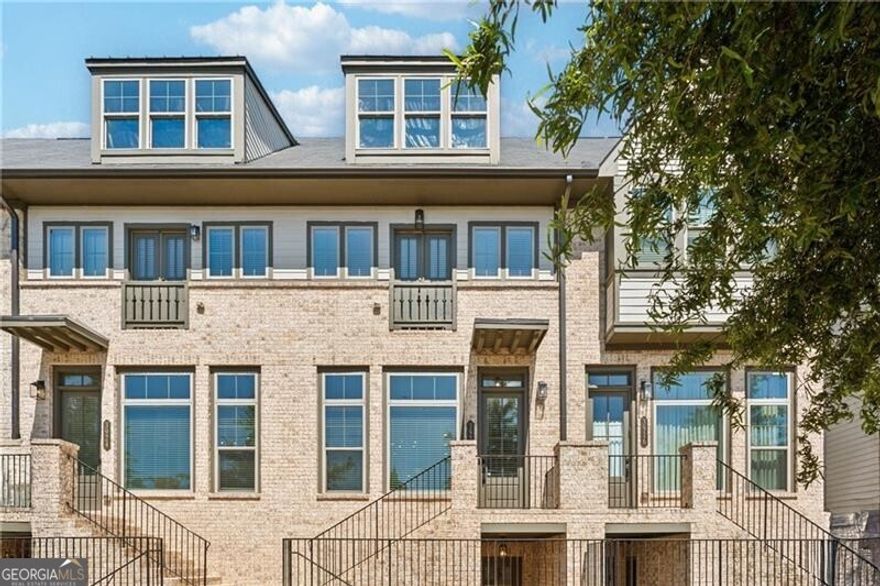 A stunning townhome in the heart of Vinings! Modern, light-filled living spaces feature an open floor plan perfect for entertaining, with high ceilings and designer finishes throughout.  Chef's kitchen with quartz countertops, large island, and stainless-steel appliances opens to a spacious living room and balcony.  The primary suite offers a spa-like bath and generous walk-in closet.  Secondary bedroom with en-suite bath provides the perfect guest retreat or home office.  Lower-level bedroom and full bath make for ideal additional guest room or home office.  Located in the gated community of Reverie on Cumberland with resort-style amenities including pool, clubhouse, and fitness center.  Just minutes from The Battery, Truist Park, and I-285/I-75.  The best of low-maintenance luxury living in one of Atlanta's most desirable locations!