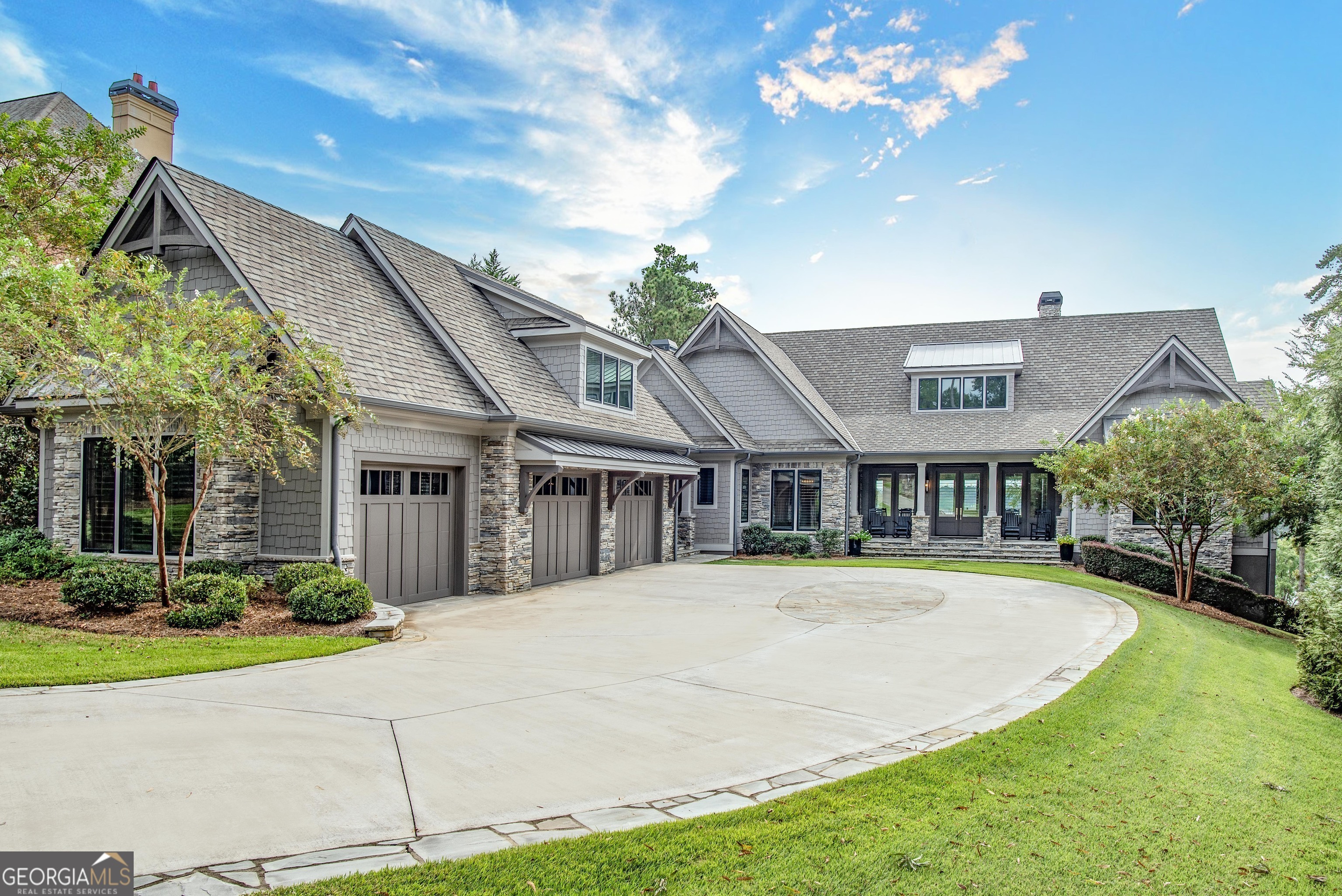 Welcome to this spectacular luxury custom home in Reynolds Lake Oconee with undoubtedly the best lake and golf views! This is a rare find - a magnificent home boasting expansive views of Lake Oconee and two world-renowned golf courses designed by premiere architects Jack Nicklaus and Tom Fazio. Launch your boat from your 24-hour boat slip to golf or dine at Great Waters, or play the famous par 3 of the Bluff nine at The National Course right in your backyard. Experience unparalleled luxury in this 3-bedroom, 3.5-bathroom, 5,868 sq ft transitional custom-built masterpiece by Calvert & White Custom Homes with all the bells and whistles you could dream of. Walk into an open floor plan that's perfect for both everyday living and entertaining, and you'll be captivated by the stunning lake and golf course vistas that stretch as far as the eye can see. The kitchen is a chef's dream with top-of-the-line Thermador appliances and granite countertops, with retractable kitchen cabinet doors for coffee maker and appliances. Wine enthusiasts will marvel at the stunning 440-bottle glass wine cellar perfect for your favorite vintages. Enjoy outdoor living in your large vaulted-ceiling porch, with a fireplace, Viking professional grill and remote control phantom screens overlooking the lake. Retreat to your spacious primary suite with breathtaking views, fireplace and indulge in the lavish bathroom that provides a spa-like experience, complemented by Caesarstone Quartz counters with luxury closets. The elevator takes you to the terrace level where a family/game room with a fireplace awaits. Walk out to the heated infinity pool and spa, the crowning jewel of this property, while soaking in the amazing lake backdrop. Enjoy the grandeur of the wide hallways that accentuate the elegance of the home, as you retreat to the spacious luxury suites. The oversized office can easily transform into a bedroom, offering unbelievable views as you work or relax. A gym is available for fitness and leisure. The long meandering driveway gives you the utmost privacy as you drive into your three-car garage. This home is the epitome of living life to the fullest. It is a gem that combines the finest craftsmanship, top-of-the-line features, and unrivaled location and views that brings the best of the lake and golf living. Membership to the Club is available.