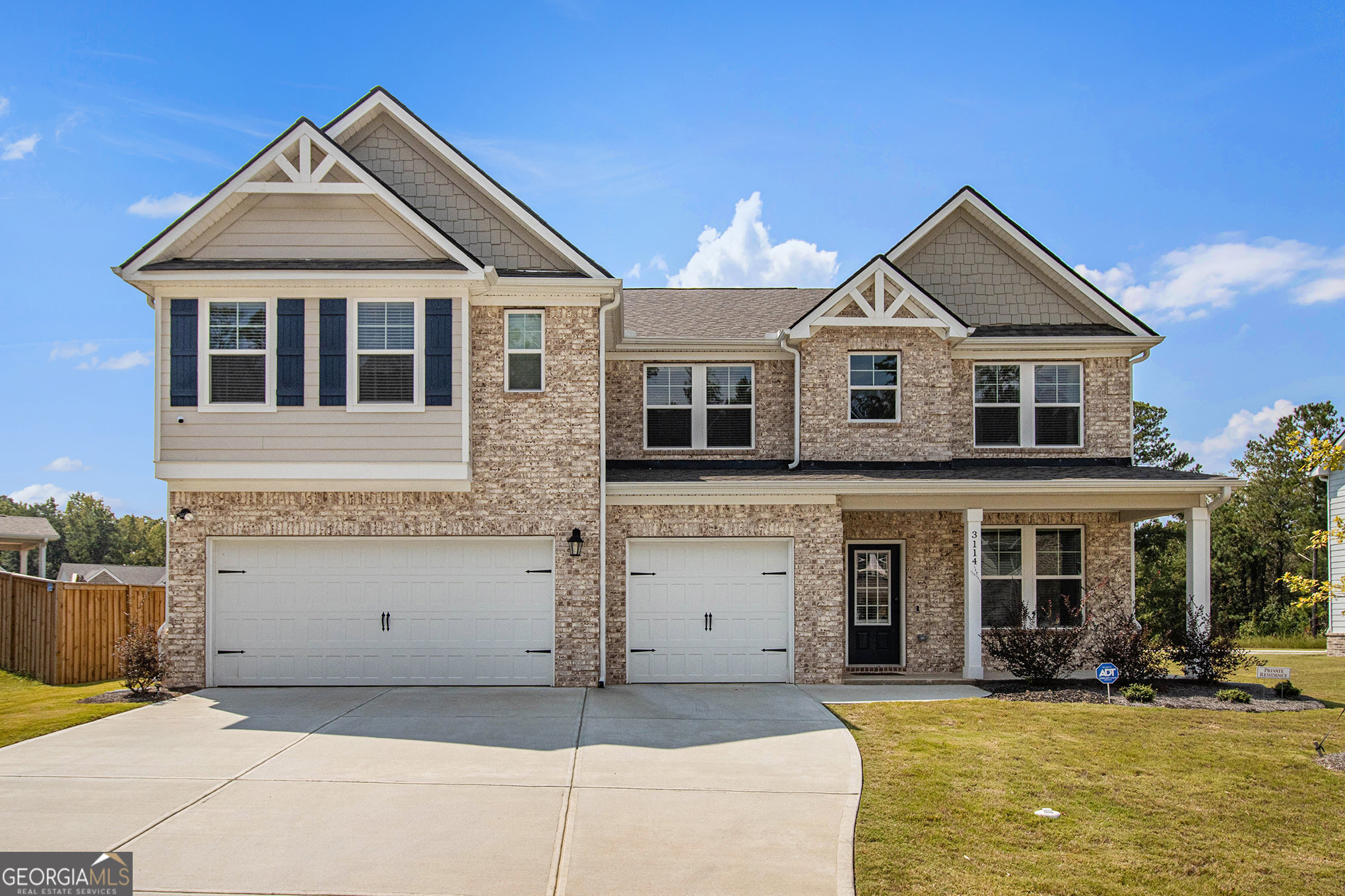 Step into sophistication with this LIKE-NEW Rosemary II floor plan, a stunning brick-front Craftsman-style home located in the prestigious Twins Shoals community. This exquisite residence boasts 5 bedrooms, 4.5 baths, and a spacious 3-car garage, along with numerous premium upgrades designed for both elegance and comfort. A dramatic two-story foyer with picture-frame molding sets the tone upon entry, leading you into an expansive open-concept great room and dining area. Impressive architectural details-majestic columns, coffered ceilings, and 2" faux wood blinds-add a refined touch throughout. At the heart of the home, the gourmet kitchen is a true chef's dream, featuring stainless steel appliances, an oversized island, a farmhouse sink, double ovens, quartz countertops, a walk-in pantry, a butler's pantry, and beautiful tile backsplash, all surrounded by abundant white cabinetry for optimal storage. Luxury vinyl plank flooring extends throughout the main level, enhancing the home's seamless flow and modern appeal. The formal dining room elevates every occasion with its elegant coffered ceiling and detailed trim work. A private guest suite on the main floor includes its own bath and walk-in closet-perfect for visitors or multi-generational living. Upstairs, a versatile loft offers additional living or entertaining space. The owner's suite is an indulgent retreat featuring a sitting area, vaulted ceilings, an oversized walk-in closet, and a spa-like bath with dual vanities, a soaking garden tub, and a fully tiled walk-in shower with ceramic flooring. Outdoors, enjoy a generous covered patio with a ceiling fan-ideal for creating a serene backyard oasis for gatherings or relaxation. Twins Shoals offers a private, tranquil setting in highly desirable South Fulton with easy access to I-285, Hartsfield-Jackson Airport, and Camp Creek Marketplace's shopping and dining options. Downtown Atlanta is just 25 minutes away, making this home the perfect blend of luxury, convenience, and lifestyle.