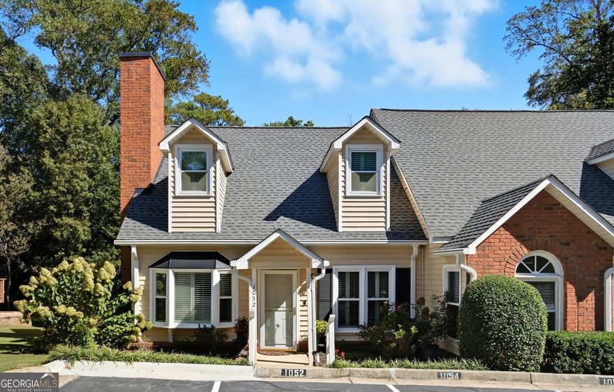 Charming End-Unit Townhome Near Historic Roswell. This beautifully maintained end-unit townhome offers effortless functionality and comfortable living. The open-concept layout connects the living room, dining area, and kitchen, creating a perfect flow for everyday living and entertaining. Step outside to the back deck overlooking a private wooded view. The primary suite on the main level features a renovated bath with a walk-in shower, custom tile, and stylish vanity, plus a spacious walk-in closet. The inviting living area includes a fireplace with built-in bookcases, Two laundry areas - stackable on main level and laundry in hall on the upper level.   Two designated parking spaces. Must see this friendly, coveted community, with only 34 units, nestled in the heart of Roswell with pool, fitness center and clubhouse. HOA includes water. Walking distance to everything Canton St has to offer - shopping, restaurants, festivals, parks!