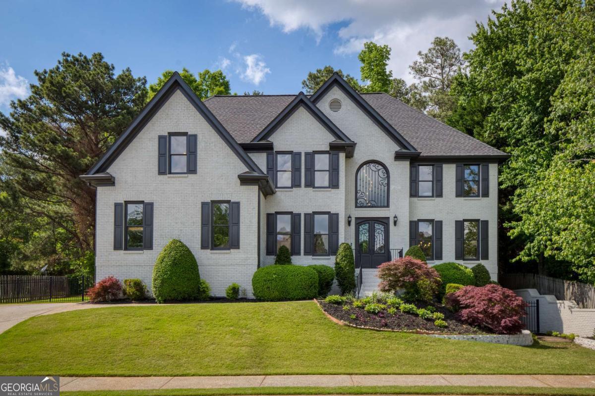 Welcome to 818 Forest Path Lane, a spectacularly renovated residence in the heart of the highly desirable Park Brooke swim and tennis community. This stunning home boasts exceptional curb appeal with its freshly painted white brick exterior, accented in timeless black for a sophisticated, modern aesthetic. Step inside the two-story foyer and immediately feel the warmth of newly refinished hardwoods that flow seamlessly throughout every level of the home. The main level offers a versatile floorplan with a spacious formal living room and elegant dining roomCoperfect for hosting holiday dinners or intimate gatherings. A main-level bedroom with full bath is currently styled as a home office, offering flexibility for work-from-home needs or guest accommodations. The heart of the home is an open-concept kitchen featuring new stainless-steel appliances, sleek quartz countertops, a stylish subway tile backsplash, and a spacious eat-in area. Adjacent is a cozy keeping room and a fireside great room with arched windows, custom built-ins, and a painted brick fireplaceCoideal for relaxed evenings with family and friends. Two sets of staircasesCoformal and casualCooffer ease of access to the upper level, where youCOll find three generous secondary bedrooms with updated bathrooms and walk-in closets. One oversized room offers dual closets and connects to a Jack-and-Jill bath, while another enjoys a private ensuite. A beautiful barn door opens to a convenient upstairs laundry room, complete with prep sink, washer/dryer, and custom wood shelving. Retreat to the luxurious primary suite with elegant tray ceilings and a private sitting room with its own fireplaceCoan inviting sanctuary to unwind. The spa-inspired primary bath is a showstopper, boasting floating vanities, a glass-enclosed walk-in shower, a freestanding soaking tub, and a cozy fireplace with mounted TVCoyour personal haven of relaxation. The finished terrace level is designed for ultimate entertaining or multi-generational living, featuring a stylish bar with sink and wine fridge, a full second kitchen with stainless appliances, and an impressive home theater. A possible sixth bedroom, full bath with walk-in shower, and a second laundry area offer complete comfort and functionality. Step outside to your private, terraced backyard oasisCosurrounded by stone walls, with ample space for a future pool, play area, or garden. The covered outdoor living area is truly an extension of the home, featuring a vaulted ceiling, built-in grill, prep sink, refrigeration, granite counters, and even a mounted TVCoideal for watching the game while grilling out. Park Brooke is one of the areaCOs premier communities, known for its exceptional amenities including a Junior Olympic-sized pool with splash pad, newly resurfaced tennis courts, clubhouse, and playground. Enjoy direct access to the Big Creek Greenway, award-winning schools, and just minutes from Avalon, Downtown Alpharetta, GA-400, and top-tier dining and shopping. This home is the perfect blend of modern luxury and timeless charmComove-in ready and designed for both everyday living and unforgettable entertaining.