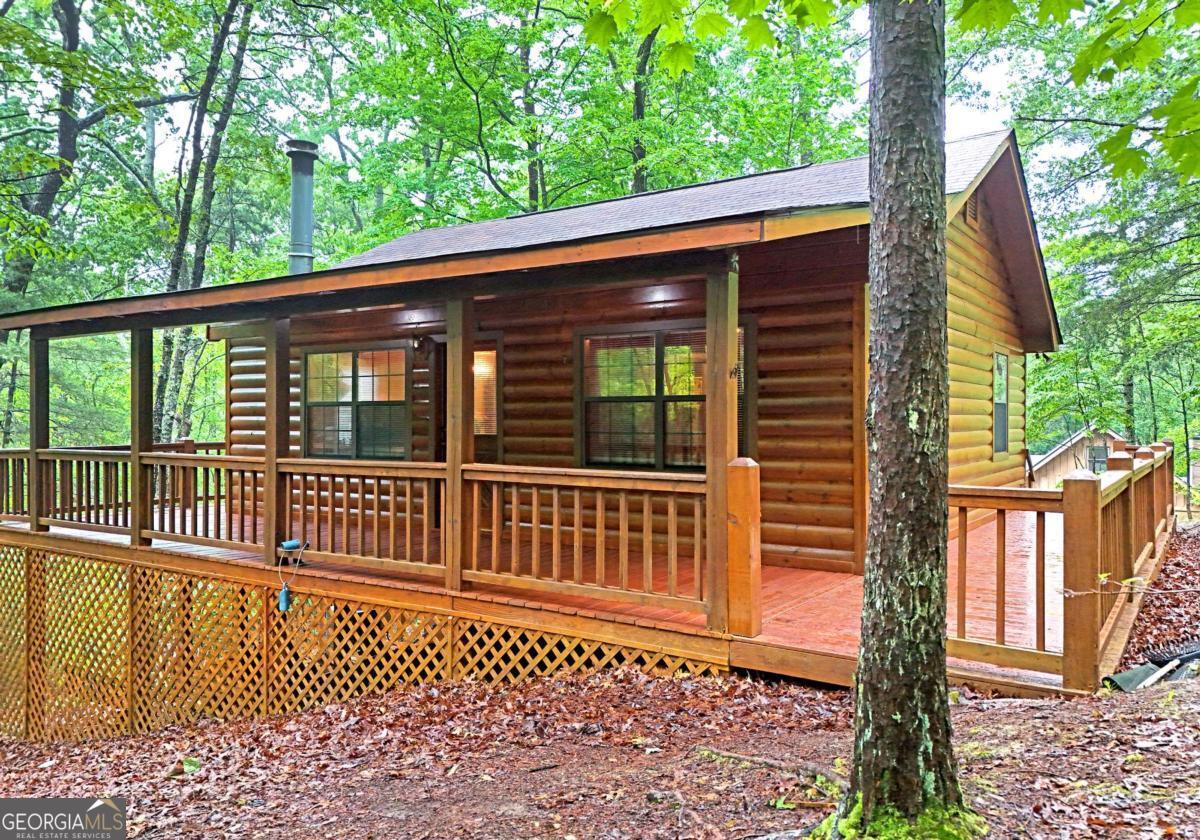 Turnkey Cherry Log Mountain Cabin - Furnished, Updated & One-Family Owned. For the first time on the market, this charming 3-bedroom, 1-bath cabin in the desirable Cherry Log Mountain community is ready to welcome its next chapter. Lovingly maintained by the same family since it was built, this home has never been rented-but it's ideally suited for a short-term rental or vacation retreat. Set on a peaceful wooded lot surrounded by mountain beauty, the cabin comes fully furnished and ready to move in. Recent updates include a new roof, HVAC system, appliances, and a freshly pressure-washed and stained exterior, offering low-maintenance living and immediate comfort. Step outside and explore the Benton MacKaye Trail right in your neighborhood, or take a short drive to enjoy trout fishing, kayaking, whitewater rafting, and some of North Georgia's finest wineries and breweries. Conveniently located between Blue Ridge and Ellijay, this cabin offers the perfect blend of seclusion and accessibility. Whether you're looking for a full-time mountain home, a weekend getaway, or a high-demand vacation rental, this one-owner gem is a rare find you won't want to miss.