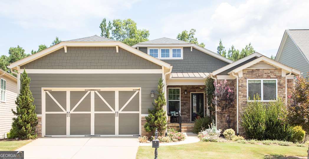 Welcome to the prestigious 55+ community of Cresswind at Lake Lanier. Nestled within a tranquil cul-de-sac, this Daylily model exemplifies meticulous ownership with hardwood flooring showcased throughout the main living spaces, plush carpeting in the bedrooms, and elegant double crown molding. The entrance features a leaded glass door leading into a refined foyer adorned with wainscoting and crown molding. The dining room is distinguished by detailed wainscoting and a dramatic tray ceiling, accommodating seating for twelve or more; this space can also be adapted as a sophisticated home office. A formal living room provides an additional separate gathering area. The gourmet kitchen is equipped with a breakfast bar, GE Profile double ovens, and an electric cooktop pre-plumbed for gas conversion. Cabinetry featuring pull-out drawers ensures ease of access. A casual dining area seamlessly connects to the family room, which includes a cozy gas fireplace framed by custom built-in cabinetry and picturesque views of the wooded backyard. The inviting enclosed sunroom offers tropical ceiling fans and EZ-Breeze windows, ideal for enjoying seasonal weather. Accessible from the sunroom, the landscaped backyard and expansive flagstone patio provide ample outdoor living space. The spacious primary suite occupies one side of the home and features a sitting area, two large closets with custom organizers, and a luxurious en-suite bath complete with a separate walk-in shower, jetted soaking tub, dual vanities, and make-up vanity. An additional flex space adjoins the bedroom, suitable for use as an office, exercise room, coffee bar, or private lounge. A secondary bedroom provides comfort for guests or family, complemented by a full bathroom with a tub/shower combination. The third bedroom offers versatility for crafts, fitness, or office use. The laundry room is equipped with washer and dryer, ample cabinetry, a utility sink, and folding counter for convenience. The unfinished terrace level is wide open, pre-plumbed for a bathroom, and ready for future customization or substantial storage. Residents of Cresswind at Lake Lanier benefit from a comprehensive array of amenities, including kayaking, fishing, courtesy boat docks, over 120 social clubs, arts and crafts facilities, pickleball, tennis, indoor and outdoor pools, a state-of-the-art fitness center, dance and fitness classes, cards and games rooms, billiards, theatrical performances, chorus, and onsite activities director and property manager. After ten years as part of this community, I can attest to the exceptional lifestyle offered at Cresswind at Lake Lanier.
