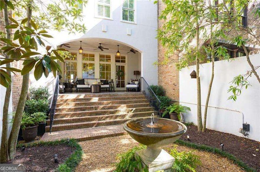 This one-of-a-kind home features a gated courtyard with Savannah charm, beautiful water fountain illuminated with landscape lighting, and a covered porch for romantic evenings. Inside, enjoy a chef's kitchen with custom cabinetry, 6-burner stove, breakfast bar, and shiplap accents. The living room offers a fireplace with custom mantle and built-ins, while the dining room boasts floor-to-ceiling windows overlooking the courtyard. Upstairs: a luxurious master suite with spa bath, two bedrooms with full baths, and laundry. Terrace level includes a bedroom or office, full bath, large storage room, and second laundry making it perfect for multigenerational living.  Loaded with upgrades: California Closets in every room, hardwood floors, custom stair runners, and a garage with storage, workbench, granite floors, and pre-wired for EV charging. There is plenty of storage throughout the home.  Walk to Downtown Woodstock for dining, boutique shopping, live music at Northside Hospital Amphitheatre, or enjoying your favorite beverage at Starbucks or Reformation Brewery. Enjoy Greenprints Trail for walking, biking, and running, and ice skating in Adair Park. Community amenities: large gated pool, dog-friendly spaces, and a park and nature trail along the creek.  Don't miss this rare opportunity-schedule your private tour today!