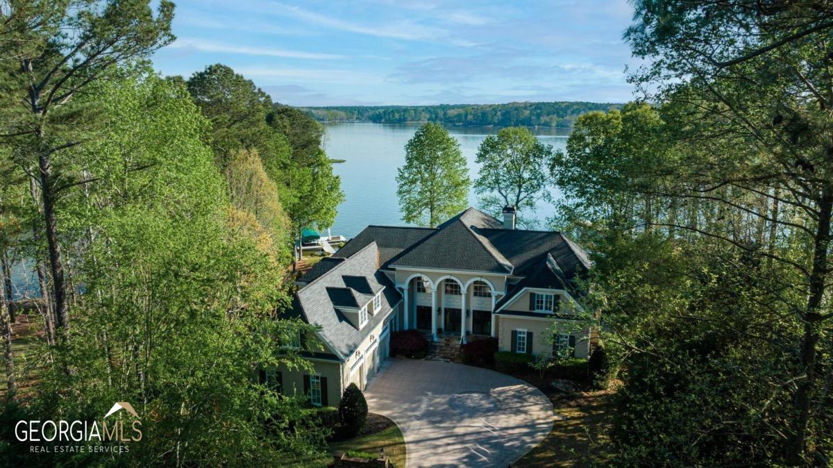 Welcome to the ultimate lakefront estate on Lake Oconee! This one-of-a-kind property was constructed with timeless style and superior craftsmanship by renowned architect Barry Light and builder Jones & Jones. Situated on a level lot with unparalleled main lake views, this 8888 square foot home is ideal for entertaining.  As soon as you enter the foyer you are drawn into the expansive open main floor great room with vaulted ceilings and fireplace.  Step out onto the covered outdoor balcony and take in the views. The owner’s suite features his and her closets, dual sinks, separate bath and walk in shower for that spa experience at home and access to the covered balcony.  The gourmet kitchen has a large sitting area and plenty of space to host gatherings.  The second floor boasts three en-suite bedrooms, two of which have private balconies overlooking beautiful Lake Oconee – perfect spots to take in a stunning sunrise! On the terrace level there is a wet bar complete with full kitchen plus gaming recreation room with fireplace along with covered patio offering screened in porch - both ideal spaces for hosting family gatherings or intimate dinners alike. Outside offers even more entertainment options – custom pool featuring waterfall feature, hot tub and gas fire pit all surrounded by established professional landscaping. Finally a 3 car garage completes this amazing package! From here it’s only minutes by boat to The Lake Club and a club membership is available to enjoy all that Reynolds Lake Oconee has to offer with six award winning golf courses, unique sporting ground, tennis, pickleball, fitness and all the recreational and culinary amenities befitting a world class private club. Don’t miss out on your chance to own an extraordinary lakefront estate like no other…Schedule your private showing today!