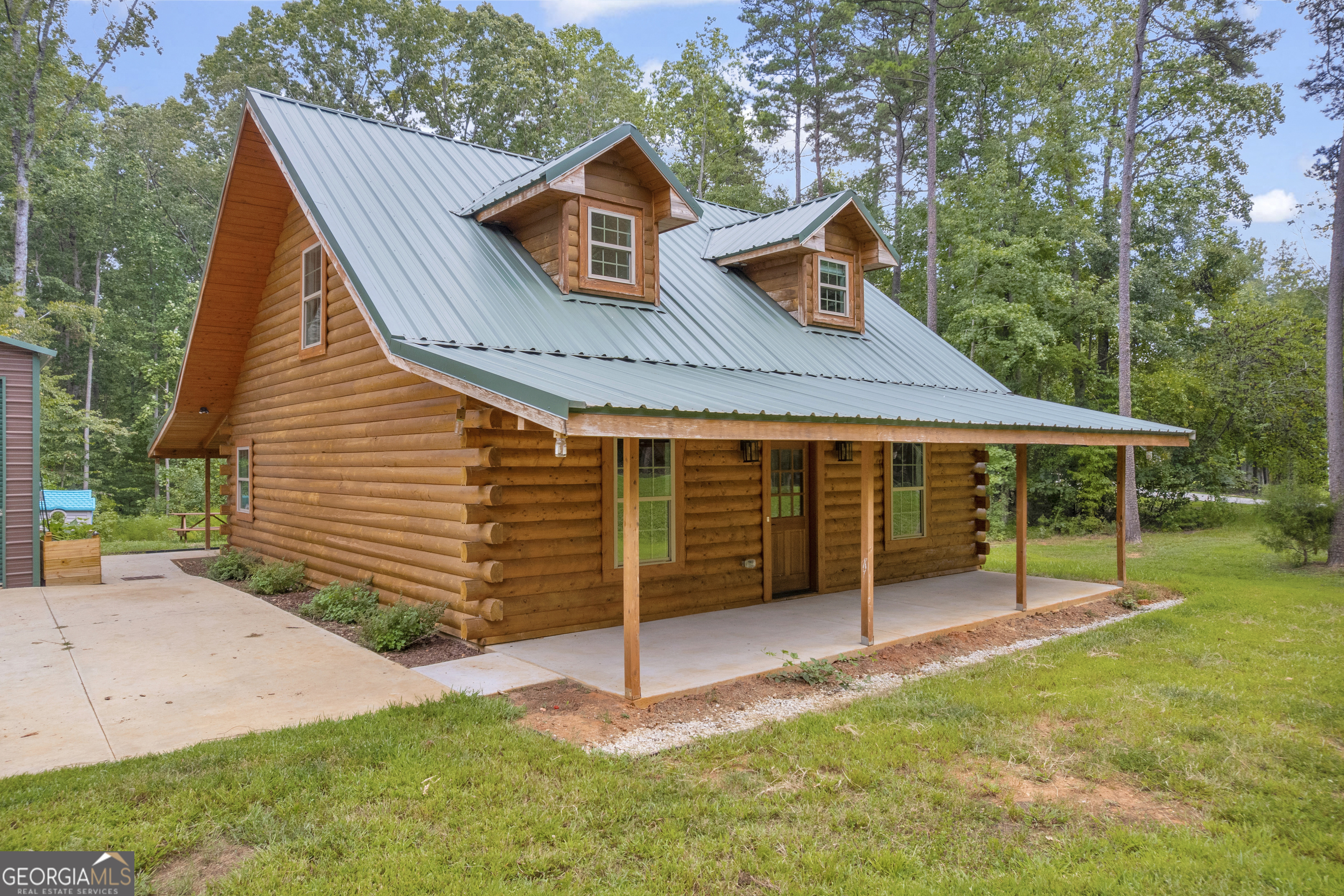 Welcome to this stunning 3 bedroom, 3 and a half bath log cabin built with sustainably sourced logs from the Satterwhite company. This lovely home is located in the sought-after Windsor Shores community, just minutes from Lake Hartwell. Nestled on a beautiful 1-acre lot, this almost-new home offers the perfect blend of rustic charm and modern convenience. Step inside to find warm wood finishes, recently refinished solid wood cabinets, an inviting open floor plan, energy efficient tankless water heater and plenty of natural light throughout. The spacious living areas flow seamlessly into a well-appointed kitchen, making it ideal for both everyday living and entertaining. Just off the kitchen is a spacious laundry room with a half bath. Each bedroom is generously sized, with the primary suite on the main floor and each bedroom offering an en suite bath with stylish tile showers with custom seamless glass doors. Outside, you'll enjoy a large, covered front porch perfect for relaxing, as well as a detached, insulated 2 car garage with water and power supply that provides ample storage and workspace. With seasonal lake views and Lake Hartwell access just around the corner, this home offers the perfect setting for a peaceful getaway or full-time living. The sellers have cherished their time in this home and neighborhood, but a shorter commute to work is now their priority. Don't miss the chance to own a move-in ready log cabin in Windsor Shores, where the best of Lake Hartwell living awaits!