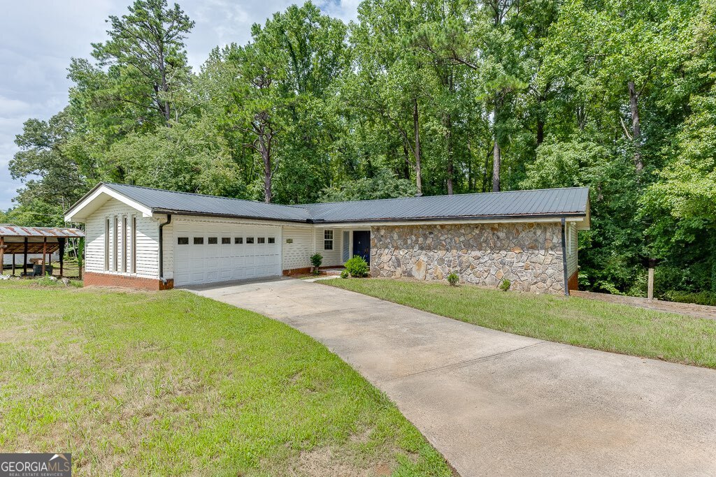 Discover this inviting 3-bedroom, 2-bathroom home in the heart of Suwanee, zoned for top-rated Sharon Elementary, South Forsyth Middle, and Lambert High School - all A+ rated by Niche. Ideally located near parks, shopping, and dining, this home offers a bright, open layout with large windows that fill the living space with natural light. The kitchen features granite countertops, stainless steel appliances, and a cozy eat-in area, while the spacious dining room boasts an electric fireplace for added charm. A dedicated office provides the perfect space for working from home, and the primary suite offers a luxurious oversized glass-enclosed shower. The full basement for additional storage. Step outside to enjoy your own private backyard retreat with a covered deck, perfect for relaxing or entertaining guests. An attached garage and extra driveway parking add convenience, while easy access to major highways makes commuting a breeze. This home combines comfort, style, and an unbeatable location.
