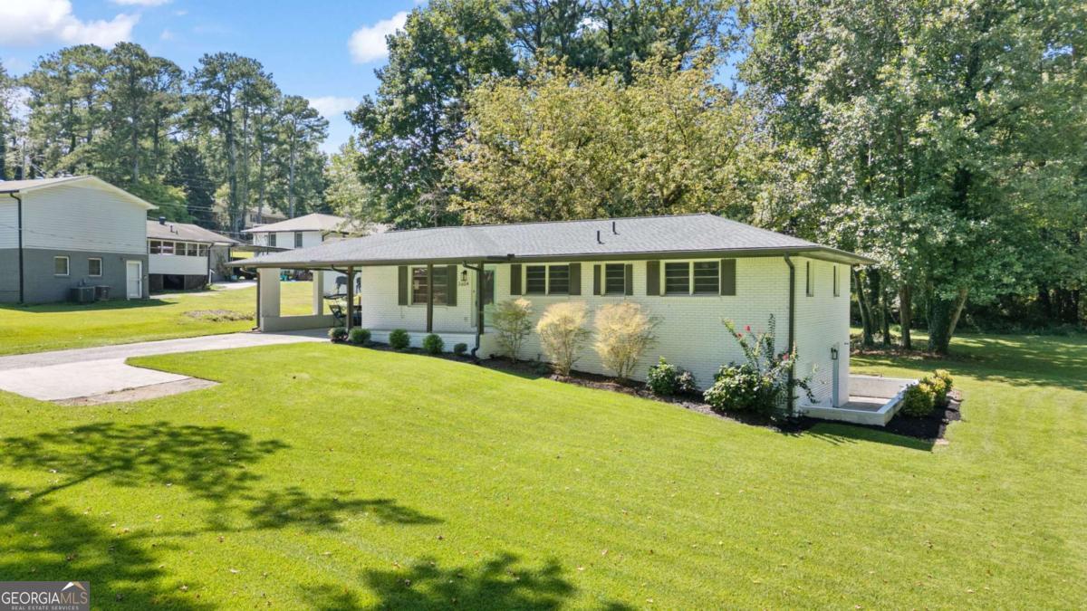 Gorgeous ranch home with fully finished basement and stylish updates inside & out! Charming curb appeal with painted door, matching carport, and front porch. Spacious open-concept main level featuring refinished original hardwood floors, a beautiful kitchen with granite counters, floating shelves, pantry, and oversized island with bar seating for guests. French doors open to a large back porch-perfect for entertaining with a quiet view! The primary suite includes a private full bath with walk-in shower. Two additional bedrooms on main with an updated hall bath and tiled tub/shower combo. Terrace level offers even more living space with hardwood floors, game room/workout room/office, whatever TWO rooms you can dream up! There is an updated full bath with double vanity. Check out the working kitchen! Backyard is absolutely stunning with lush grass, shady oak trees, and exterior entrance from the terrace level. Major systems including HVACs, water heater, furnace, electrical, and plumbing were all updated within the last few years for peace of mind. This home has it all-fresh finishes, two kitchens, multiple living areas, and an entertainer's backyard-every inch has been thoughtfully cared for!
