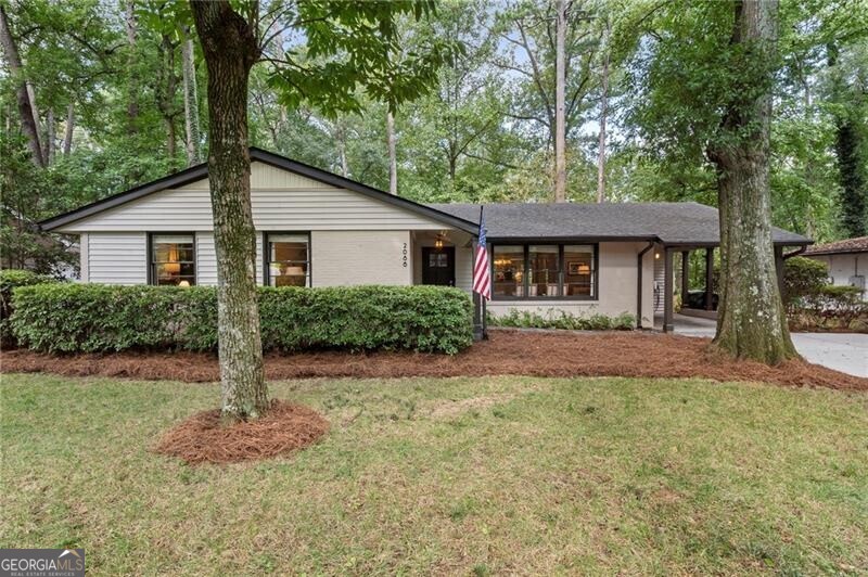 This stunning, fully updated ranch-style home sits on a generous half-acre lot, just minutes from Morningside Nature Preserve, Piedmont Park, Emory University, and Morningside Village! The bright, open floor plan features hardwood floors throughout and a spacious layout with multiple living and dining spaces. The updated kitchen is complete with ceiling-height custom cabinetry and slide-out shelving, granite countertops, premium KitchenAid appliances, apron-front sink, and a built-in corner bench with storage. The recently renovated laundry room adds both style and functionality, offering additional shelving and ample storage as well as a wine and beverage fridge. French doors from the large family room open onto an expansive back deck overlooking a private, tree-lined backyard. Also off the family room, is a convenient powder bathroom. The oversized primary suite with dual custom closets, soaking tub, marble walk-in shower with frameless glass doors, and double vanities with quartz countertops. Two additional spacious bedrooms share a beautifully renovated full bath with tub/shower combination. Additional features include a whole house dehumidifier and air purification system and unfinished basement area with exterior entry from the deck -- perfect for additional storage. This move-in-ready home offers timeless finishes, thoughtful upgrades, and a location that's hard to beat.