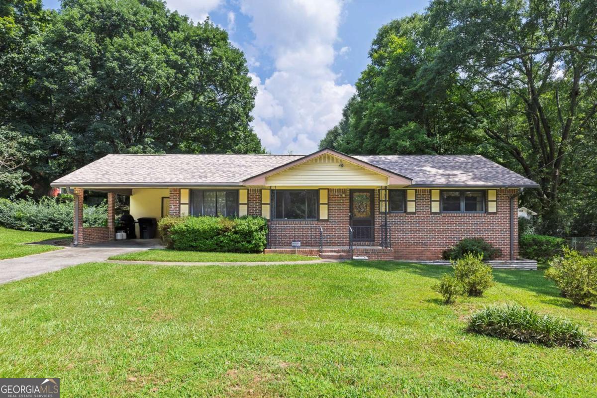 This charming 4-side brick ranch-style home offers the perfect blend of comfort and potential, nestled within the serene surroundings of Smyrna. Situated on a spacious lot ideal for gardening, recreation, or future expansion, the property includes an outbuilding for convenient storage. Inside, the light-filled living room welcomes you with views of the front yard and flows seamlessly into the adjoining dining area. The cozy kitchen, featuring wood cabinetry, provides an excellent opportunity for customization and includes a side door that opens to the carport, where a utility closet houses the washer, dryer, water heater, and freezer. The primary bedroom includes an adjoining half bathroom for added convenience, while two additional bedrooms and a full hall bath complete the home. This property is full of character and is ready for its next chapter. It's a wonderful opportunity to own a slice of Smyrna's tranquility and transform it into a dream home filled with personal touches, cherished memories, and endless possibilities.