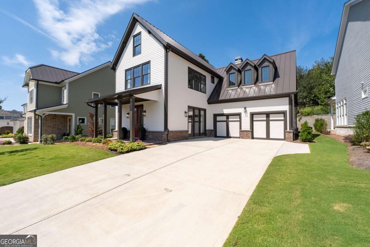 Special buyer opportunity! Ask about qualifying for a 5% APR with our preferred lender-a rare find in today's market! Step into timeless style and modern comfort in this beautifully designed 5-bedroom Vickery home, where thoughtful details and flexible spaces meet everyday luxury. The primary suite on the main level offers a peaceful retreat, while the upstairs junior suite-with built-in workspace-can easily flex as a media room, second office, or guest hideaway. From the moment you enter, you're welcomed by a formal dining room wrapped in tongue-and-groove planked walls, with a dramatic cast concrete fireplace surround and custom built-ins adding character and charm. The chef's kitchen is a true standout-featuring a 36-inch Wolf gas range, designer exhaust hood, soft-close cabinetry that reaches the ceiling, quartz countertops with waterfall island, and a custom walk-in pantry with wood shelving that blends form and function effortlessly. In the great room, exposed brick walls and a cozy fireplace set a warm, inviting tone. French doors lead to the covered brick patio, where soaring ceilings and a waterfall feature create a one-of-a-kind outdoor escape-ideal for relaxing or entertaining year-round. Upstairs, you'll find four additional bedrooms, each with private en-suite baths. One could serve as a private office, while the other bedrooms offer flexibility. Located in the heart of Vickery, just a short stroll to Vickery Village's shops, dining, and community green spaces, this home truly has it all. Schedule your tour today and fall in love with where luxury, comfort, and convenience come together.