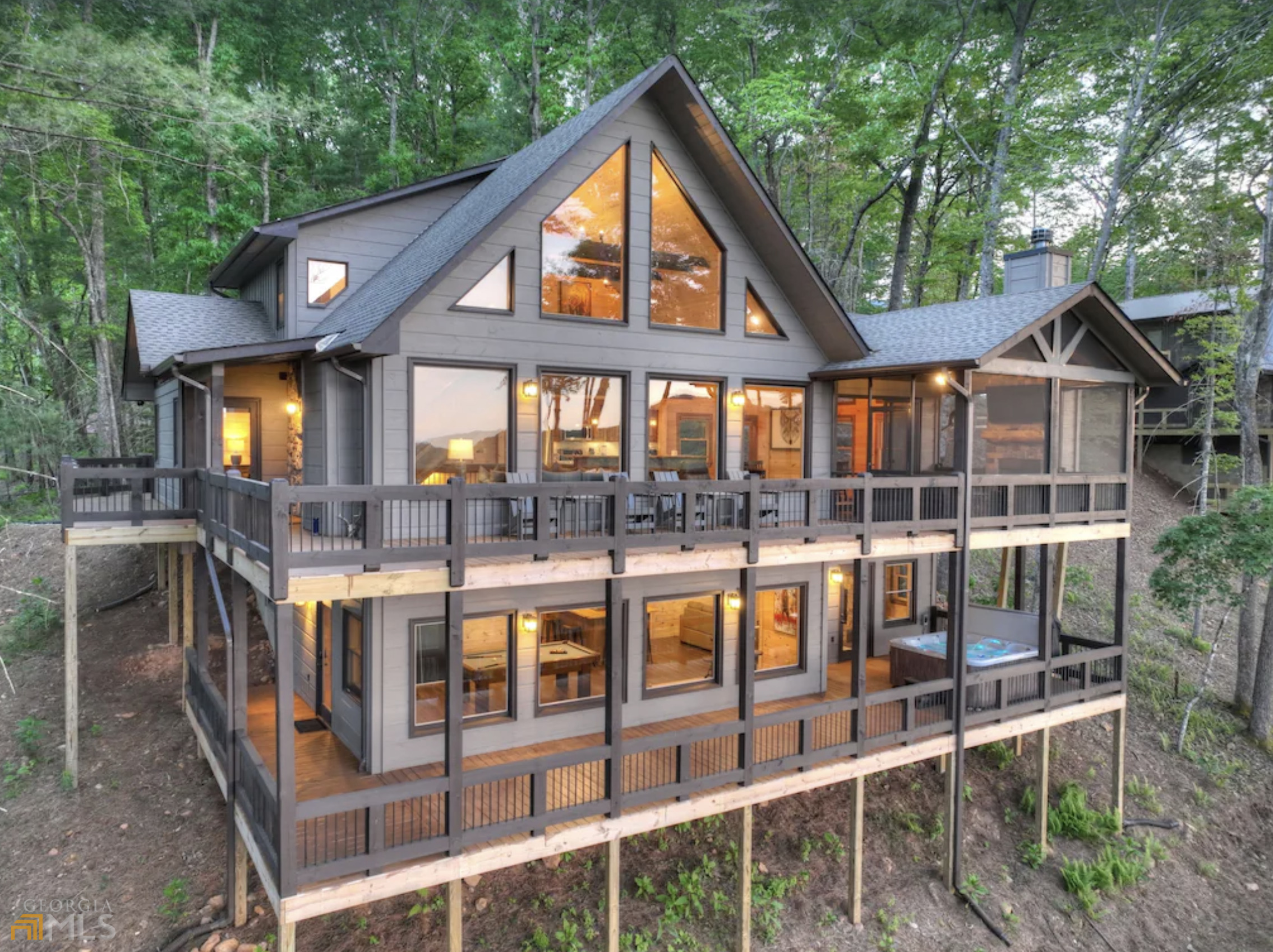 This is a custom cabin, finished in January of 2022. Relax in this SUCCESSFUL RENTAL, ALL FURNISHED property. The View is an amazing range of LONG RANGE MOUNTAINS and woods all around. The living room offers a spacious seating area and large living area with a gas fireplace. The kitchen and dining area, which are both part of an open floor plan with the living room. The kitchen is fully equipped with all your cooking needs and appliances, double oven, and a farm house style stainless sink. The dining area is situated with open windows all around. Just off the dining room is an amazing outdoor space completely screened in, with an outdoor lounge and fireplace! On main level you'll find the master bedroom offering a king bed and the spa like master bathroom, you have a large walk in shower and an amazing soaking tub complete with heated floors! Half bath on main. The lower level den and Game room features a bar complete with seating, a sink and mini drink refrigerator, upstairs is complete with 2 additional bedrooms and a Jack and Jill bathrooms. This cabin is the perfect mountain retreat!