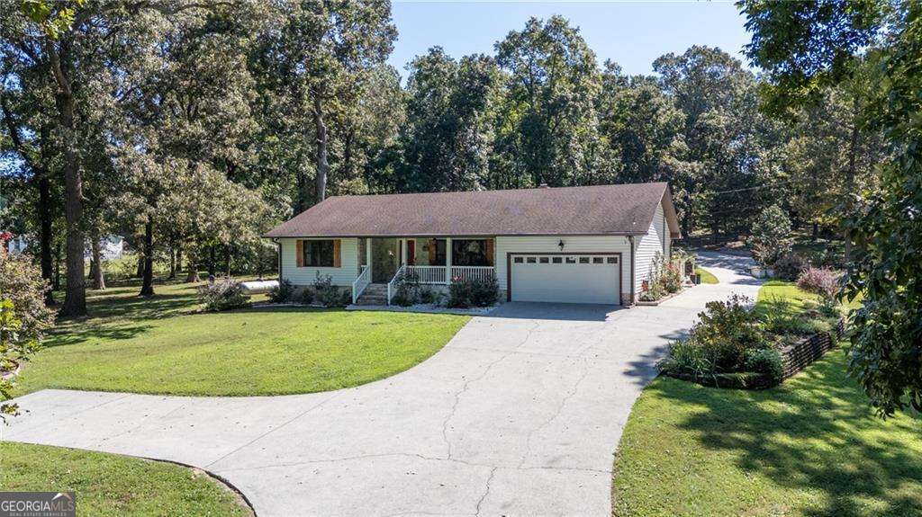 An elegant and inviting county house is nestled 10 minutes from town on alluring and private 5.74-acres. Originally built in 1985 and thoughtfully expanded in 2000, this residence now offers over 3,000 square feet of beautifully curated living space. From the moment you step inside, you're captivated by the generous family room, where rich, vibrant colors set a tone that is both bold and tranquil. A wood-burning stove adds character and comfort in this gathering space. Off the family room, you'll find a private en-suite bedroom and a full guest bath. On the opposite side of the family room, the laundry room doubles as a well-designed mudroom, finished with a mirrored backsplash, abundant cabinetry, and a utility sink. The light-filled kitchen is truly the centerpiece of the home, with a soaring vaulted and beamed ceiling, exposed original brick, and a succession of windows and doors that provide natural light and direct access to the courtyard. A professional gas range, solid stone counters, and an oversized center island anchor the space. Located off the kitchen, the primary suite offers a retreat of its own, featuring a separate soaking tub, walk-in shower, and generous proportions. A rear flex room provides versatility as the perfect home office or guest room. Outdoors, the property unfolds into a lifestyle retreat. Over five acres of completely fenced, meticulously maintained grounds are framed by a gated entrance and a canopy of mature trees. A 36x40 workshop with a dock door is ready for projects or hobbies and a 24x30 pole barn with electricity offers additional storage. A gazebo with fire pit and an appointed outdoor kitchen invite year-round entertaining. This home is more than walls and windows-it is a place of genuine beauty, serenity, and purpose. A rare opportunity to enjoy privacy, space, and thoughtful design in one remarkable setting.