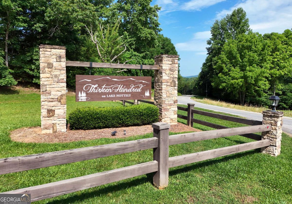 This exceptional corner lot is located inside the beautiful Thirteen Hundred on Lake Nottely gated community. This stunning 2.67 acre lot offers breathtaking year-round long-range mountain views and is truly a must-see opportunity! Enjoy the 5* Lodge/Clubhouse with stunning views, a luxurious saltwater pool, kiddie splash pool, fireplace, grilling and seating areas and full kitchen to enjoy the company of friends and family in a beautiful setting offering a blend of privacy, luxury and outdoor activities. Enjoy the marina including community boat docks with private boat ramp, swim platform, canoe/kayak launching area and outdoor grilling station. Enjoy the equestrian park with barn for your horse, riding area and walking trails. Ample camper and boat storage is available at a minimal cost for residents only. Paved roads, underground utilities, high-speed internet and public water available. Short-term rentals are allowed. Conveniently located close to Blairsville, Blue Ridge, Hiawassee and Murphy, NC for shopping, dining, golf, wineries and more. Come plan your dream home in the North Georgia Mountains!