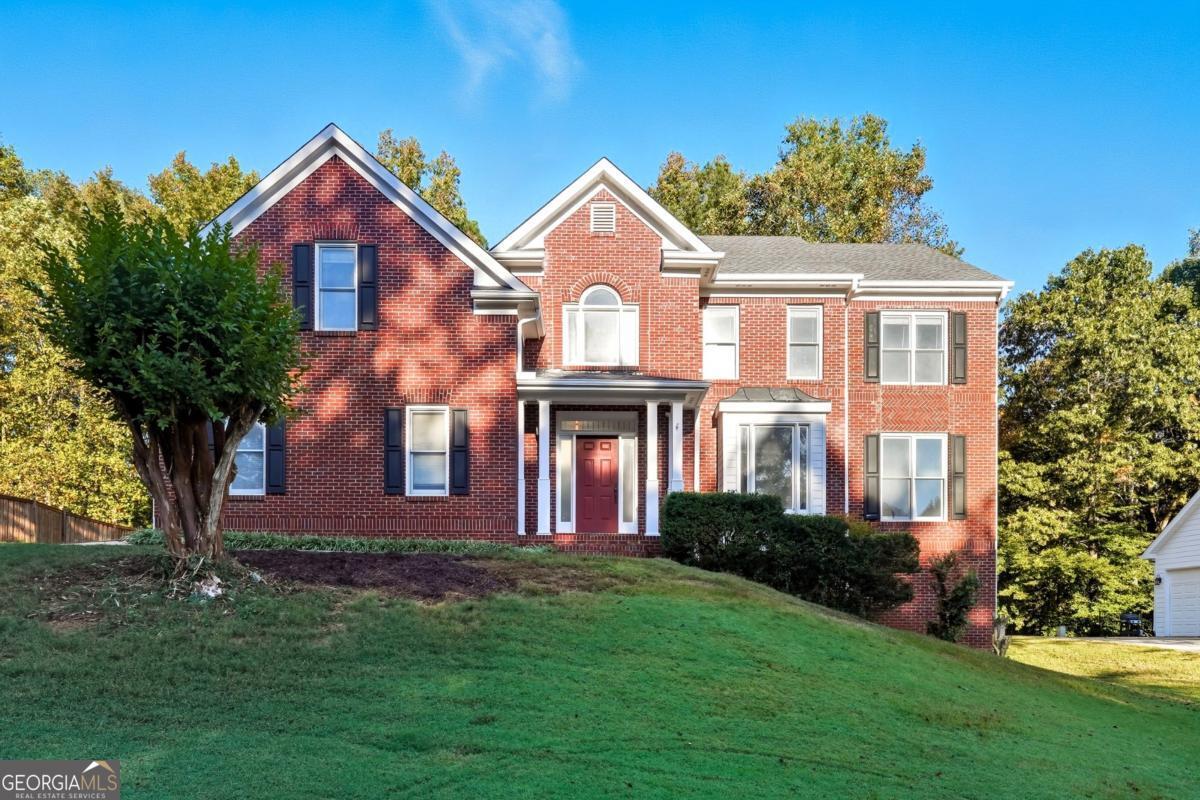 Discover timeless elegance and modern comfort in this beautiful brick home located in The Hamptons Grant, - a quiet, tree-lined community known for its timeless curb appeal and ideal Alpharetta location, with Forsyth Taxes. Near Avalon, Halcyon, downtown Alpharetta, and top-rated schools, this property combines classic craftsmanship with the conveniences of today's luxury living. Step into a bright two-story foyer with gleaming hardwood floors and a striking wrought-iron staircase. The open floor plan flows effortlessly through the formal living and dining rooms into a spacious family room filled with natural light and centered around a cozy brick fireplace - perfect for everyday living and entertaining. Enjoy the sunny breakfast nook framed by bay windows overlooking the backyard. The kitchen features granite countertops, stainless steel appliances, custom white cabinetry, and a butler's pantry. A laundry room with built-in sink and a half bath on the main floor add everyday convenience, making this home as functional as it is elegant. Upstairs, retreat to the large primary suite with tray ceilings and sitting area. The spa-inspired bathroom offers a soaking tub, glass-enclosed shower, and dual vanities. Create a closet oasis in the immense primary walk-in closet with natural light. Three additional bedrooms provide ample space for family, guests, or a home office. The daylight basement offers incredible potential for a home theater, gym, playroom, or in-law suite and features direct exterior access. Enjoy outdoor living on the expansive back deck overlooking a private, tree-lined yard - ideal for morning coffee or weekend gatherings. Located on a quiet street with mature landscaping, this move-in-ready Alpharetta home is just waiting for your custom touch.