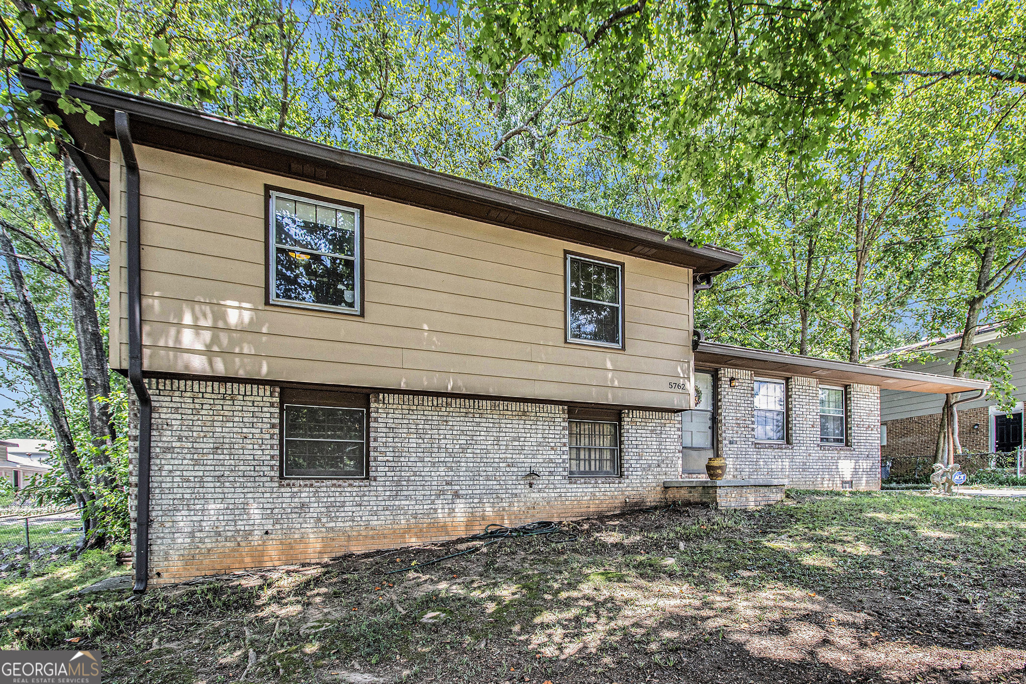 Welcome to this charming split-level home nestled on a peaceful wooded and fenced lot. Featuring 3 bedrooms, 2 full bathrooms, and an unfinished basement, this home offers a solid foundation and a blank canvas ready for your personal touch and remodeling vision. The open kitchen includes a spacious breakfast area that overlooks the serene, tree-lined backyard, perfect for birdwatching and enjoying quiet mornings. The large living room features a gas fireplace, adding warmth and character to the main level. Upstairs, you'll find all three bedrooms, including a primary suite with custom built-in shelving and a private bath with a walk-in shower. Step outside to enjoy the fenced backyard with a large deck, ideal for entertaining, relaxing, or dining under the trees. A charming shed, once a playhouse, offers extra storage or creative use. The covered carport is equipped with an electric vehicle charging plug for added convenience. This home is full of potential, ready for you to move in, update, and make it your own.
