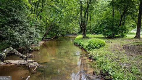 ~CASCADING WATERFRONT LOT ON WOLF CREEK IN THE FARMS ON WOLF CREEK~ This 4.05 acres is an estate size lot with a breathtaking picture perfect setting nestled with towering hardwoods & native flora galore. The terrain is "to die for" w/ very level access to the creek & all of the property is very flat & gentle, making this entire tract usable! Property has access to public water, internet, phone, cable & has been perked for septic system. This is the perfect spot to build your dream mountain home, whether your home away from home or you're looking to relocate to. Located in The Farms of Wolf Creek, an old rock quarry this is an amazing setting, you'll be convenient to both downtown McCaysville & Blue Ridge w/ no steep roads and all paved roads.