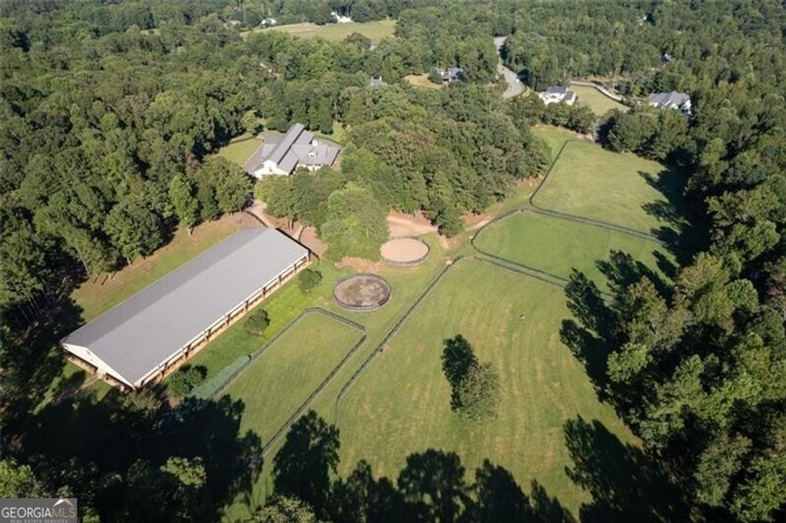Located on a 38.59+/- acre setting in the heart of Alpharetta horse country, Serenity Farm offers ideal amenities for a private equestrian estate or a professional training operation. Combining the beauty of reclaimed millwork with the strength of concrete construction, the 14-stall custom stable was designed for both premium horse care and entertainment.  The 100x220 lighted, covered arena with slant wall and Futuretrack footing is suitable for many riding disciplines and/or events.  The open and light stable is situated for maximum airflow and drainage and features high T&G ceilings and extra wide aisles with rubber pavers; matted, 14x14 stalls with ventilated front and rear doors;  two large tack rooms plus an owners private tack room all climate-controlled with custom woodwork, built-in tack cabinets and ample saddle/bridle racks; two matted wash racks with stainless cabinets/fans/heaters; separate vet/farrier space; large feed room, equipment/supply room and two blanket rooms.  Overlooking the pastures and riding arena you will find a wrap-around covered porchperfect for entertaining with French doors leading to the full kitchen with lounge and to the office with private bath.  Additionally, there is a large laundry room with built-in cabinetry, two guest baths and two second floor apartments with a kitchen and two baths.  There is also a 2BR/1BA cottage with separate driveway as well as a hay barn, equipment barn and storage shed.  The four-board fenced property features 14 pastures/paddocks, two round pens and wooded riding trails. Bring your builder to create a country compound for generations to come!Located between Canton and Milton, Serenity Farm has easy access to restaurants, shopping and entertainment in Alpharetta, Crabapple, Roswell and Woodstock.