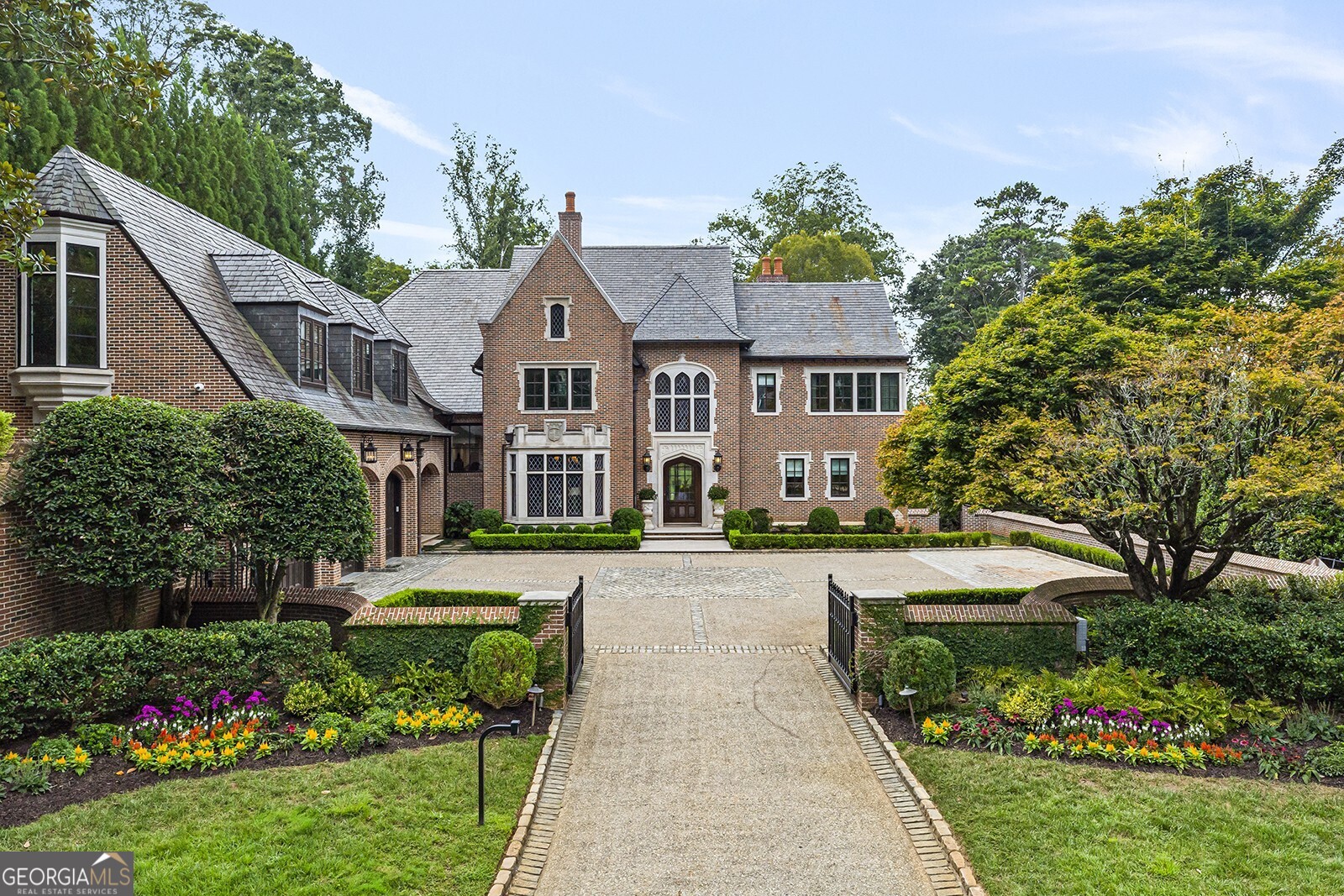 Flawlessly designed by internationally acclaimed architect William T. Baker with English Tudor style elements, this truly remarkable home built by Dan Mattox with Builders II is both deeply luxurious and exceptionally comfortable. The meticulously curated interior creates an unforgettable impression with imported antique doors, centuries-old stained-glass windows, artisanally crafted ceiling details, hand-hewn reclaimed wood beams, Baccarat chandeliers, hand-painted wall coverings, Francois & Co. limestone mantels, intricate millwork and custom steel doors/windows. Lofty ceiling heights and an abundance of natural light create inviting spaces including the dramatic entrance hall, richly appointed office, living room and banquet-sized dining room. Highlighted by a stunning barrel cove ceiling, the show-stopping kitchen features a large Butler's Pantry, separate breakfast room, Calcutta marble surfaces, a suite of high-end appliances and two large islands overlooking the vaulted fireside keeping room. The oversized main level primary suite provides a true oasis with a bay window sitting area, cozy fireplace, luxuriously appointed bath complete with heated floors, a generous soaking tub, luxurious steam shower room and two custom walk-in closets. Private upper-level offers 5 spacious en-suite bedrooms, a convenient laundry room and an additional flex space for entertaining. The expertly designed terrace level boasts charming brick floors, a generous wine room, home theatre, workout room and private guest suite. Inviting outdoor living spaces are found throughout the 2.33 +/- acre grounds including a charming gazebo and firepit, Bocce Ball court with beverage center, covered loggia, sport court, outdoor fireplace seating area, thatched roof potting shed cottage, heated PebbleTec pool with a luxuriously appointed guest/pool house. Additional standout features include a spacious Nanny suite, whole-house generator, eight HVAC systems, slate roof with copper gutters, whole house generator, water purification system, built in air purifier/dehumidifier and complete surround system throughout the property.  Not a detail missed on this exquisite estate on a premier street in Buckhead!